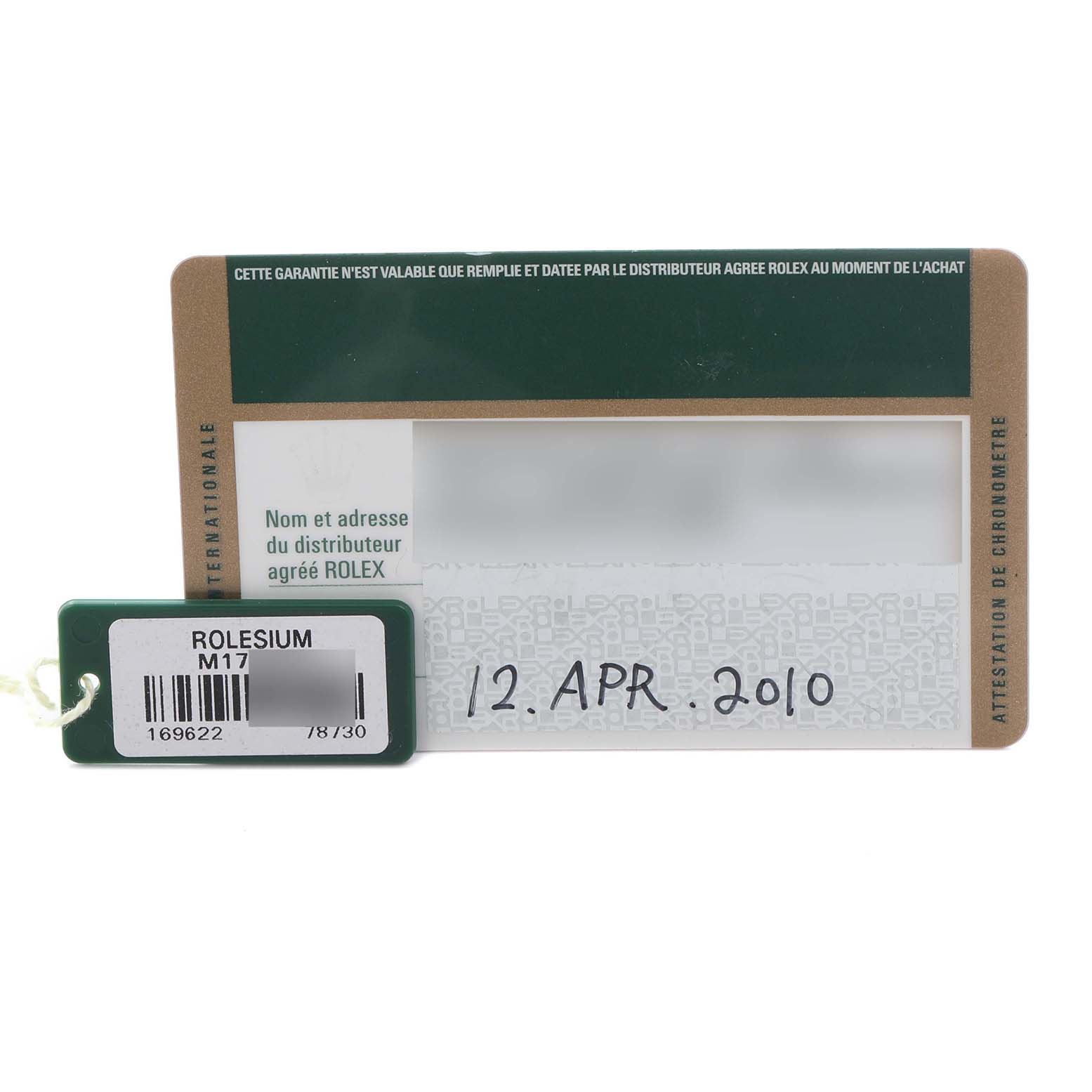 The image shows a guarantee card and a tag for the Rolex Yacht-Master 169622 Women
s Stainless Steel Silver Dial 169622 Women
s Stainless Steel Silver Dial watch, viewed from above.