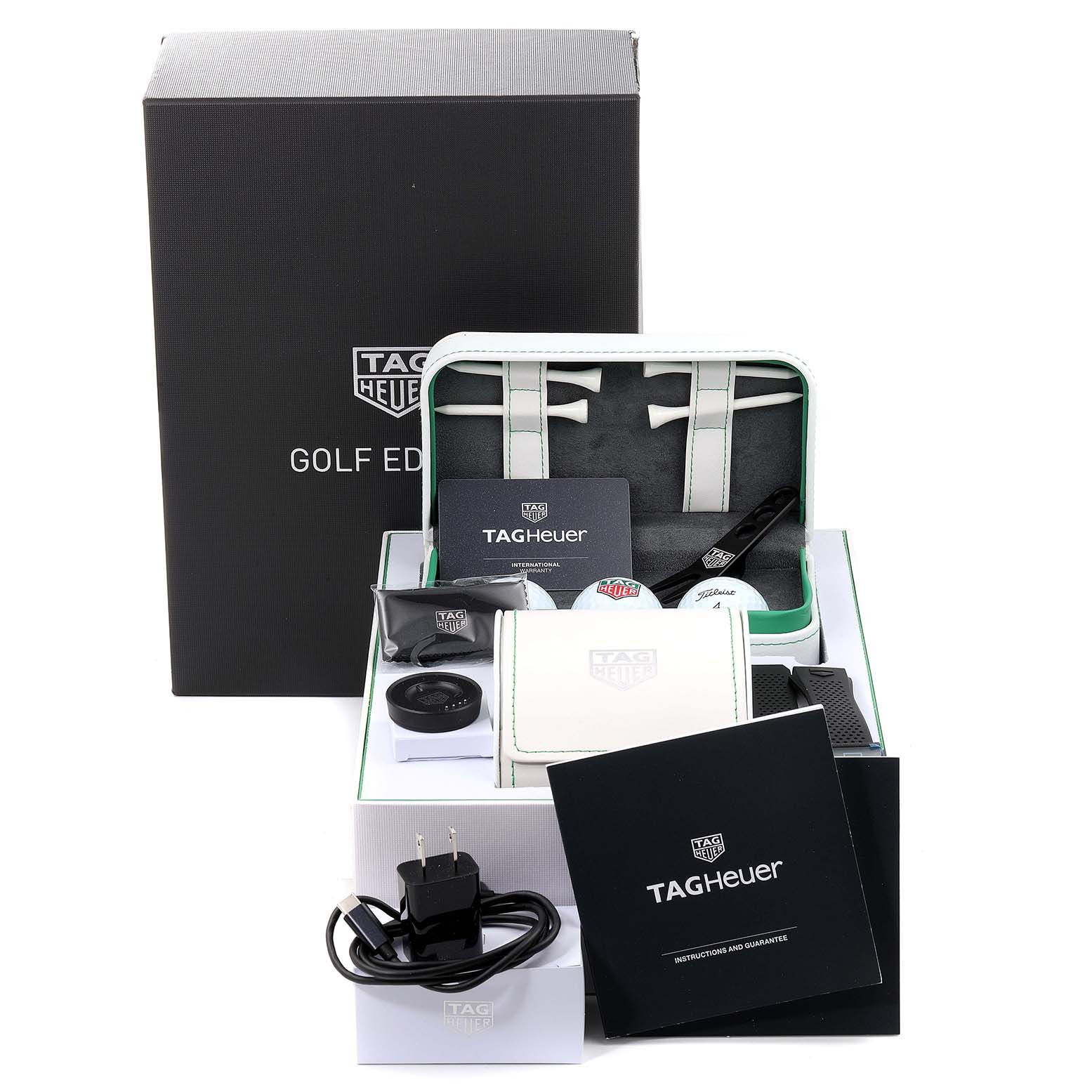 The image shows the Tag Heuer Connected SBG8A82.EB0206 Men's Titanium  SBG8A82.EB0206 Men's Titanium  Golf Edition watch accessories, including a charger, manuals, and a carrying case, viewed from the front.