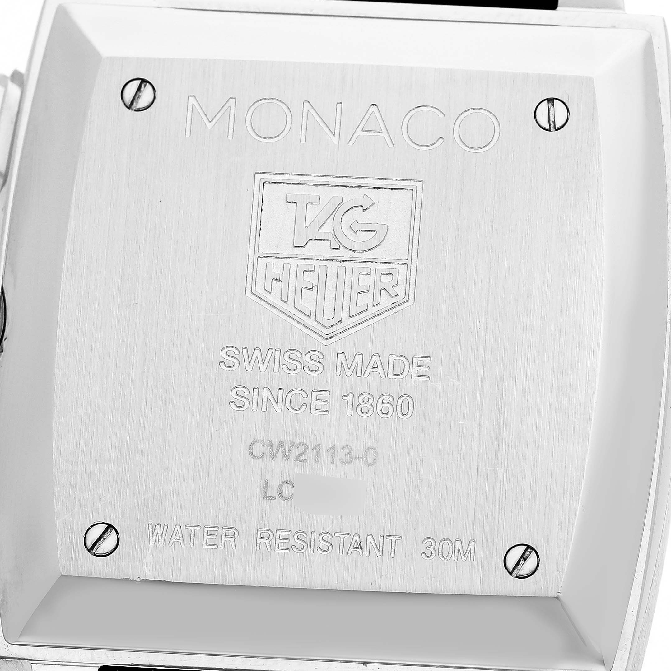 The image shows the back of a Tag Heuer Monaco CW2113 Men's Stainless Steel Blue Dial watch, highlighting engraving details and screws.