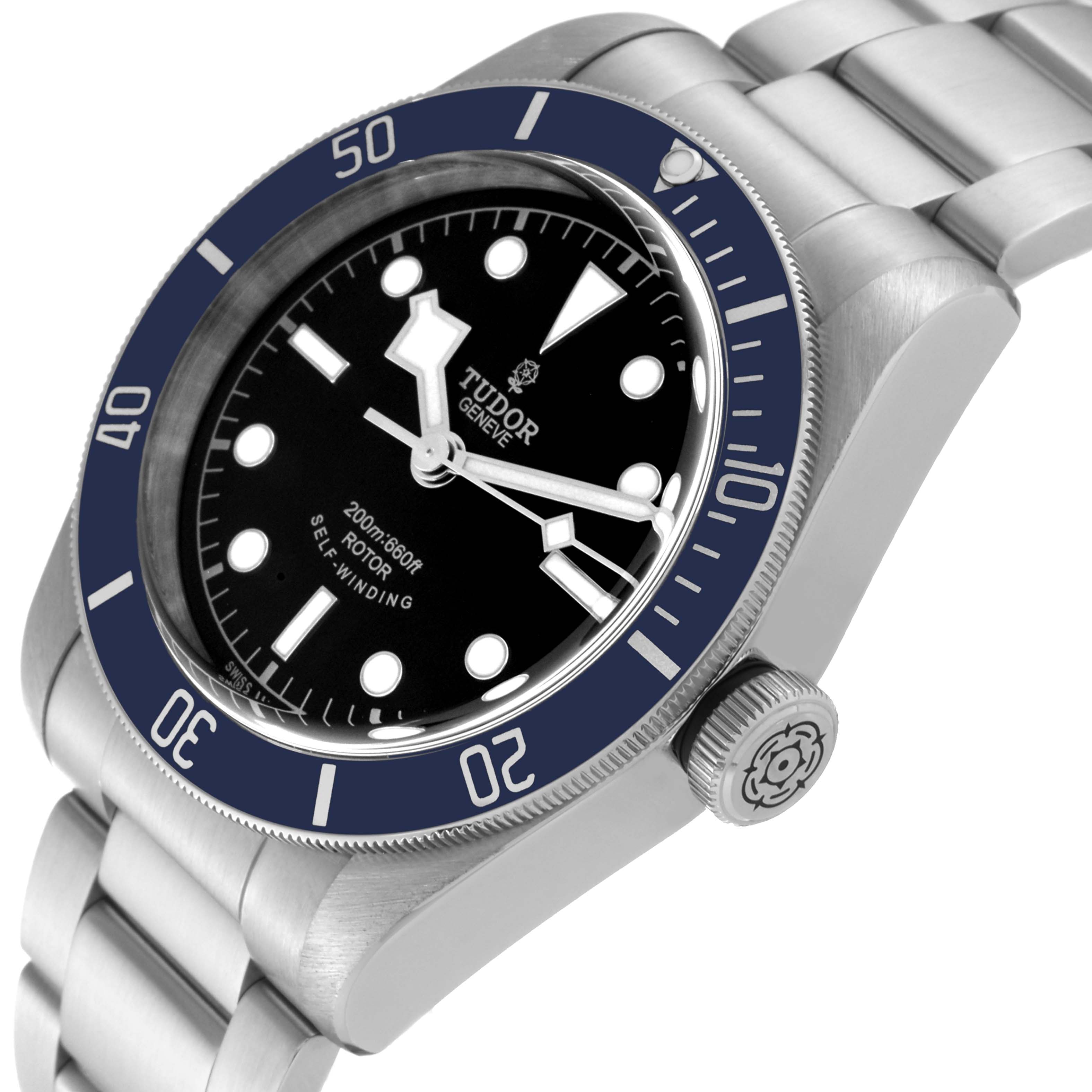 The image shows a Tudor Heritage Black Bay 79220B Men's Stainless Steel Black Dial 79220B Men's Stainless Steel Black Dial watch angled from the top right, featuring the bezel, dial, crown, and part of the bracelet.