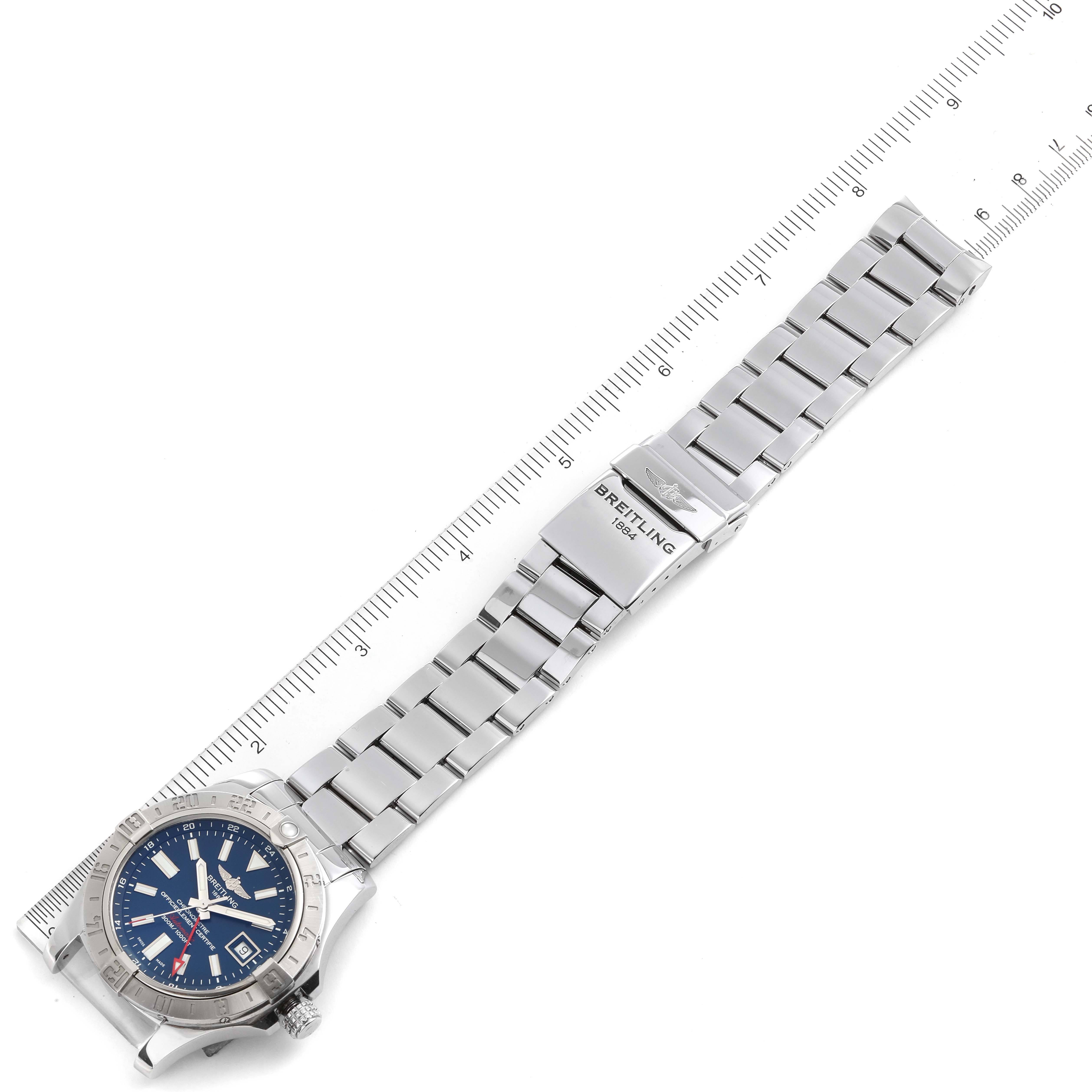 The Breitling Avenger A3239011-C872-170A Men
s Stainless Steel Blue Dial A3239011-C872-170A Men
s Stainless Steel Blue Dial watch is shown from an angled top-down view, highlighting its silver bracelet and blue dial, next to a ruler.