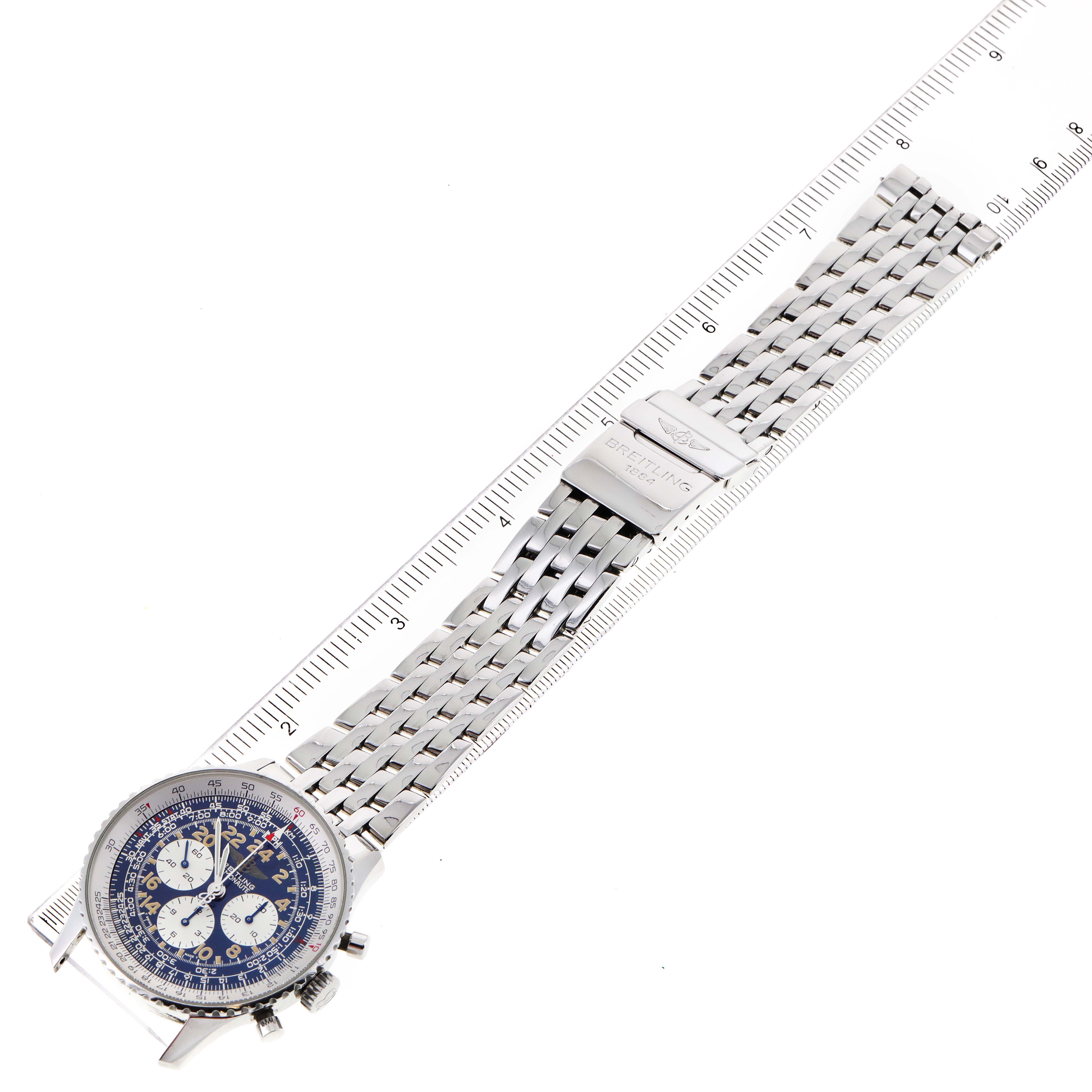The image shows a Breitling Navitimer A12022 Men
s Stainless Steel Blue Dial A12022 Men
s Stainless Steel Blue Dial watch laid flat with a metal bracelet and a ruler beside it for scale.