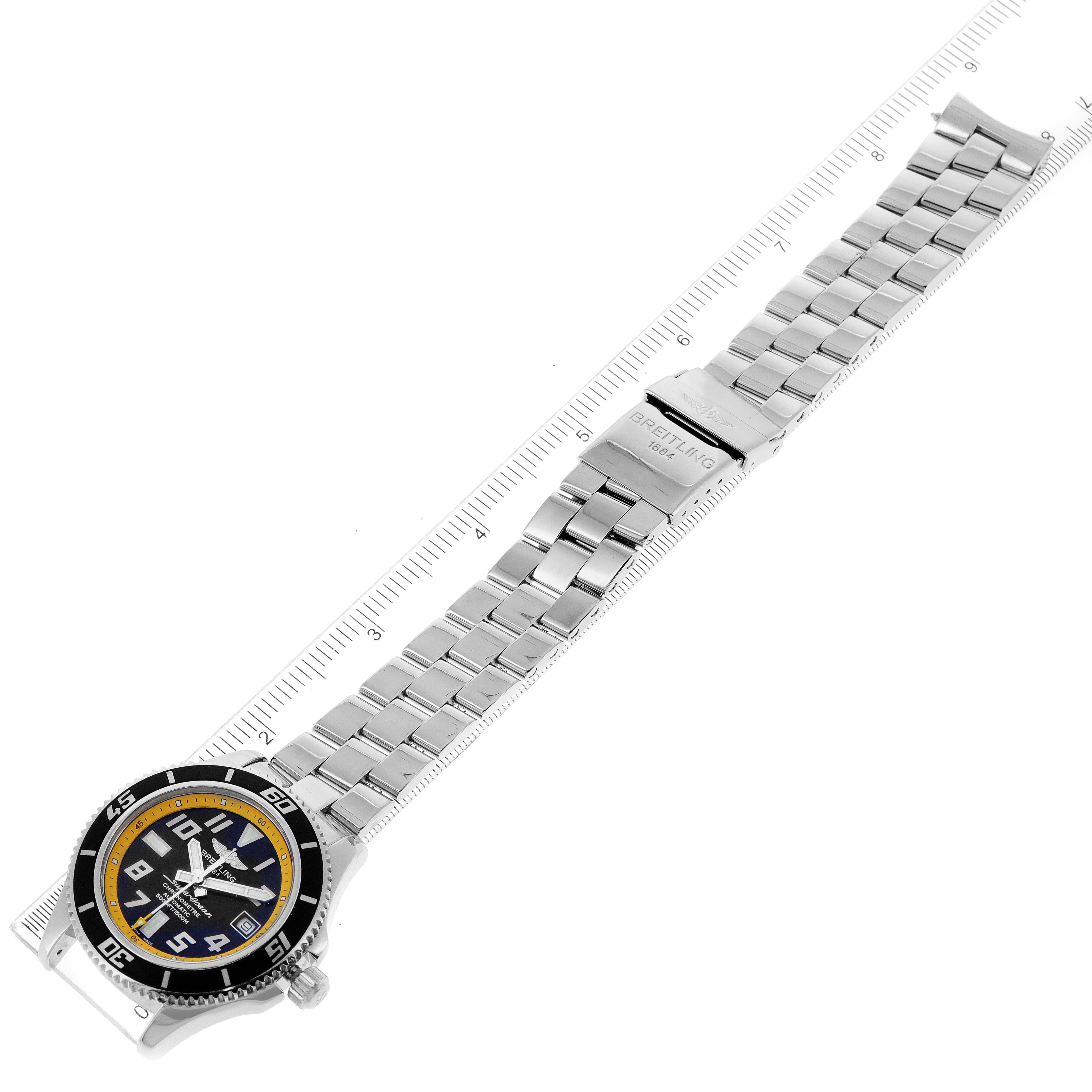 The image shows a top view of a Breitling Superocean A17364 Men
s Stainless Steel Black Dial A17364 Men
s Stainless Steel Black Dial watch with a full metal bracelet, clasp, and ruler for scale.