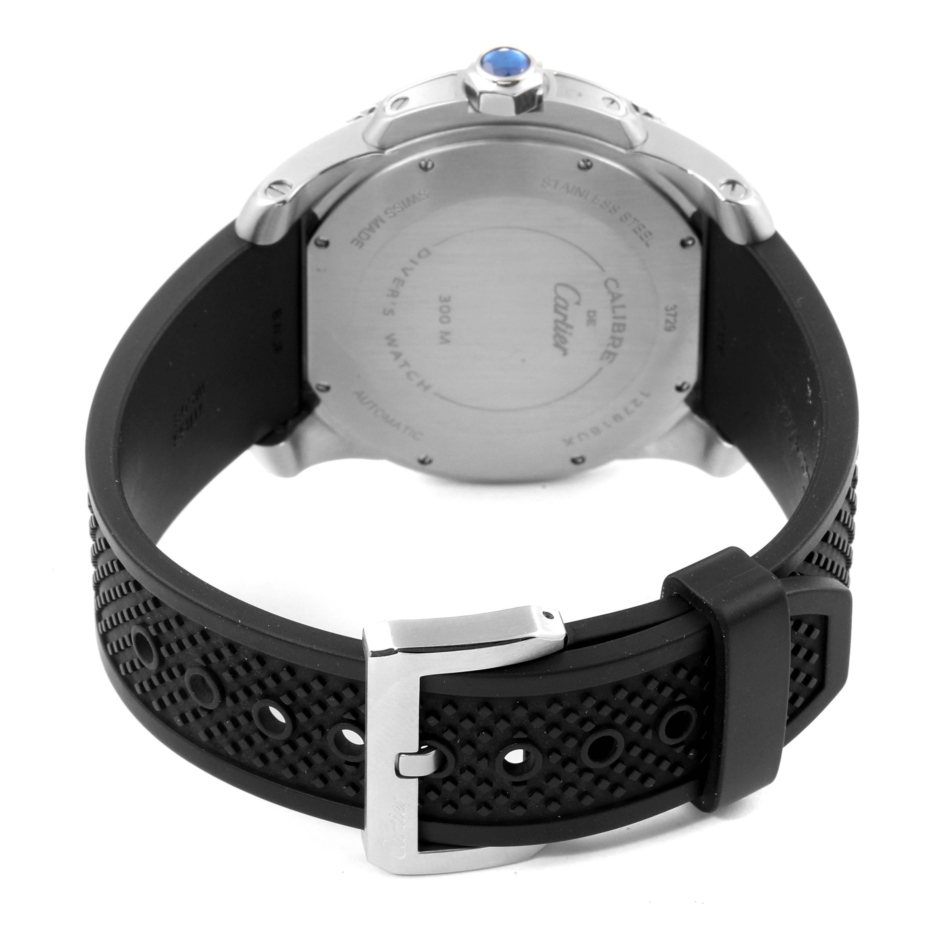The image shows the back view of a Calibre de Cartier watch by Cartier, highlighting the case back and black rubber strap with buckle.