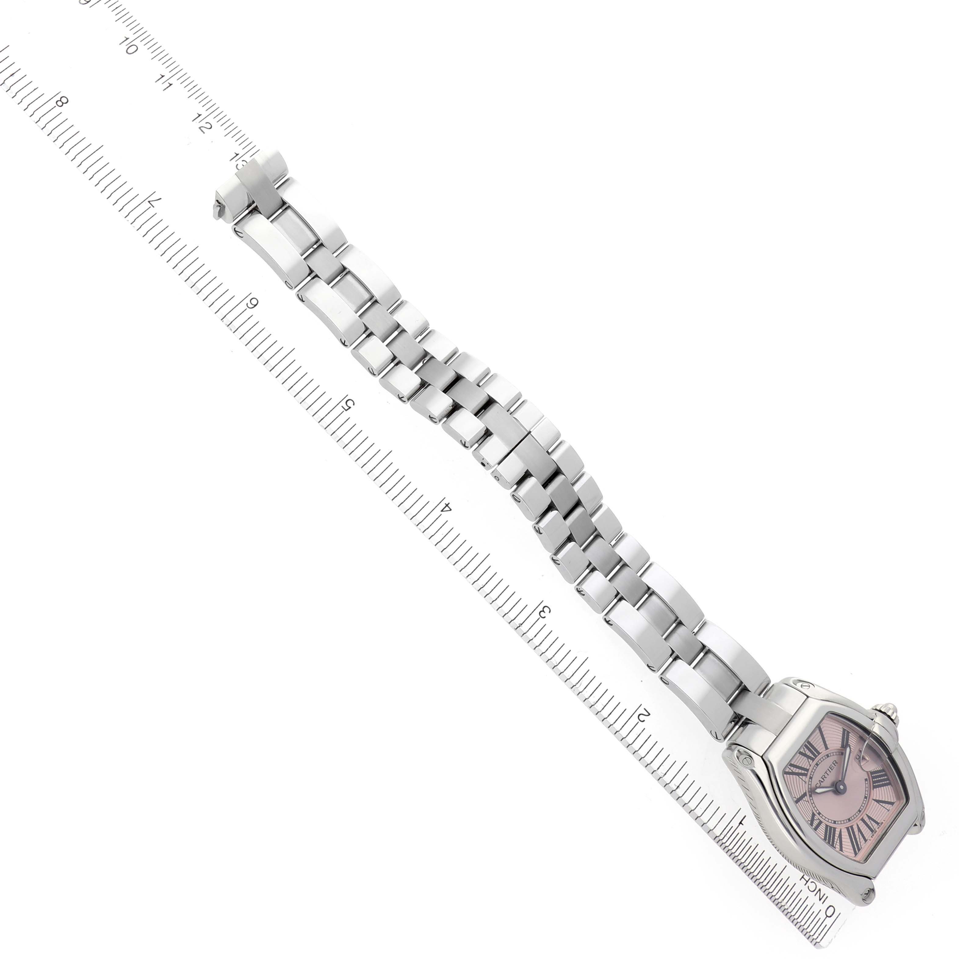 The Cartier Roadster W62017V3 Women's Stainless Steel Pink Dial W62017V3 Women's Stainless Steel Pink Dial watch is shown from an overhead angle, featuring the face and full bracelet alongside a ruler for scale.