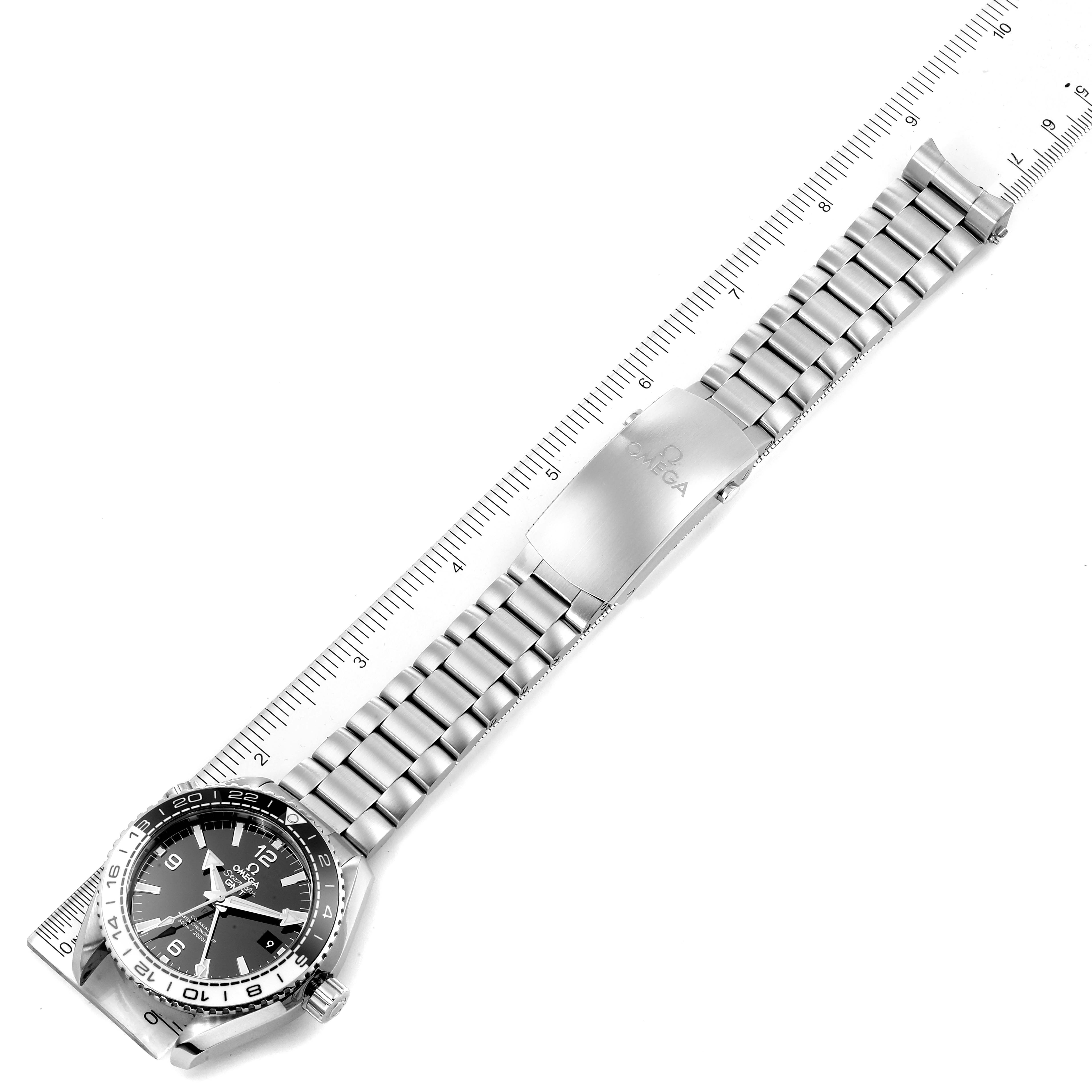 The image shows a top-down view of an Omega Seamaster 215.30.44.22.03.001 Men
s Stainless Steel Black Dial 215.30.44.22.03.001 Men
s Stainless Steel Black Dial watch, displaying the face, bezel, bracelet, and clasp next to a ruler.