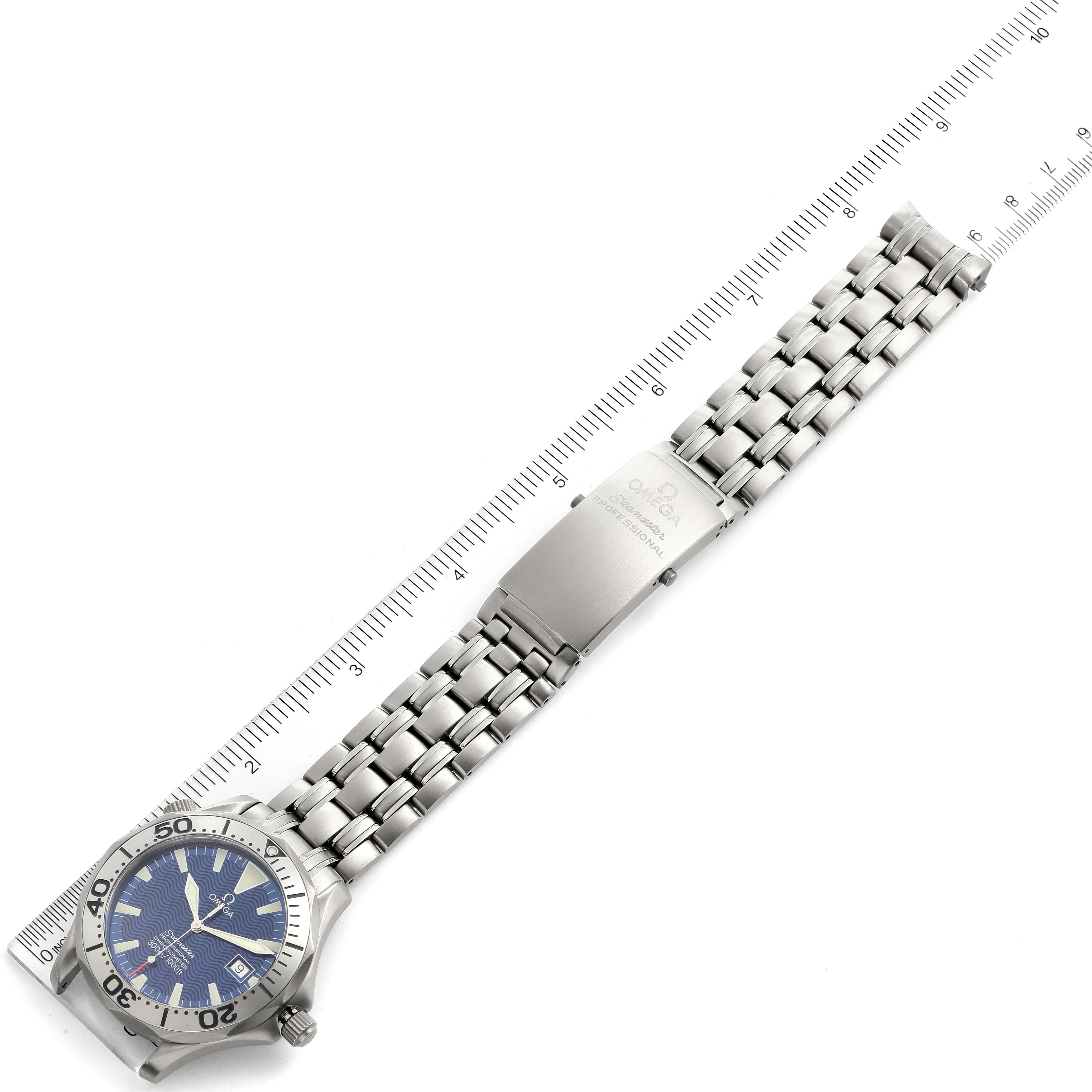 The Omega Seamaster 2231.80.00 Men's Titanium Blue Dial 2231.80.00 Men's Titanium Blue Dial watch is shown from a top-down angle, displaying the face and metal bracelet next to a ruler.