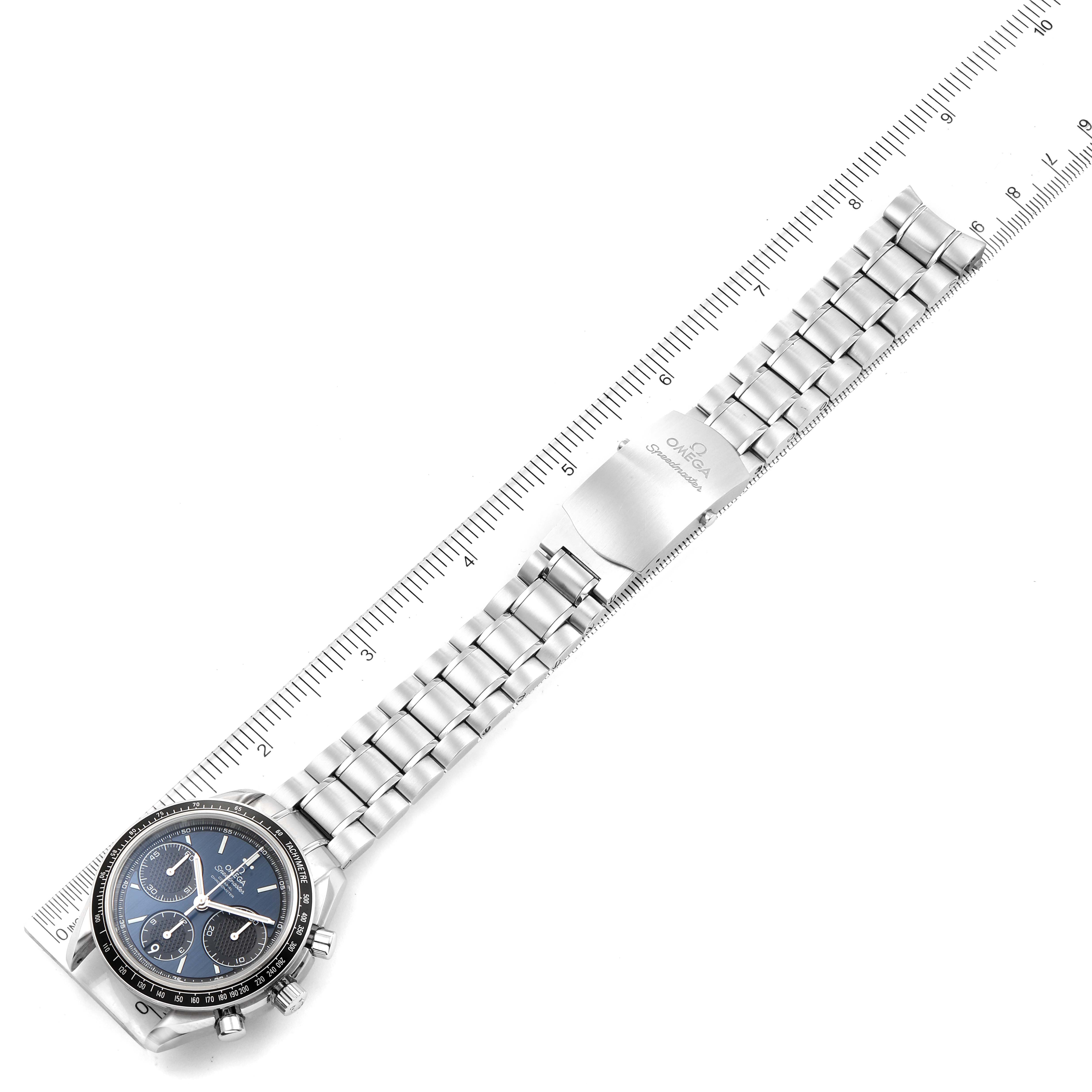 The image shows an Omega Speedmaster 326.30.40.50.03.001 Men
s Stainless Steel Blue Dial 326.30.40.50.03.001 Men
s Stainless Steel Blue Dial watch laid flat with a ruler next to the metal bracelet.