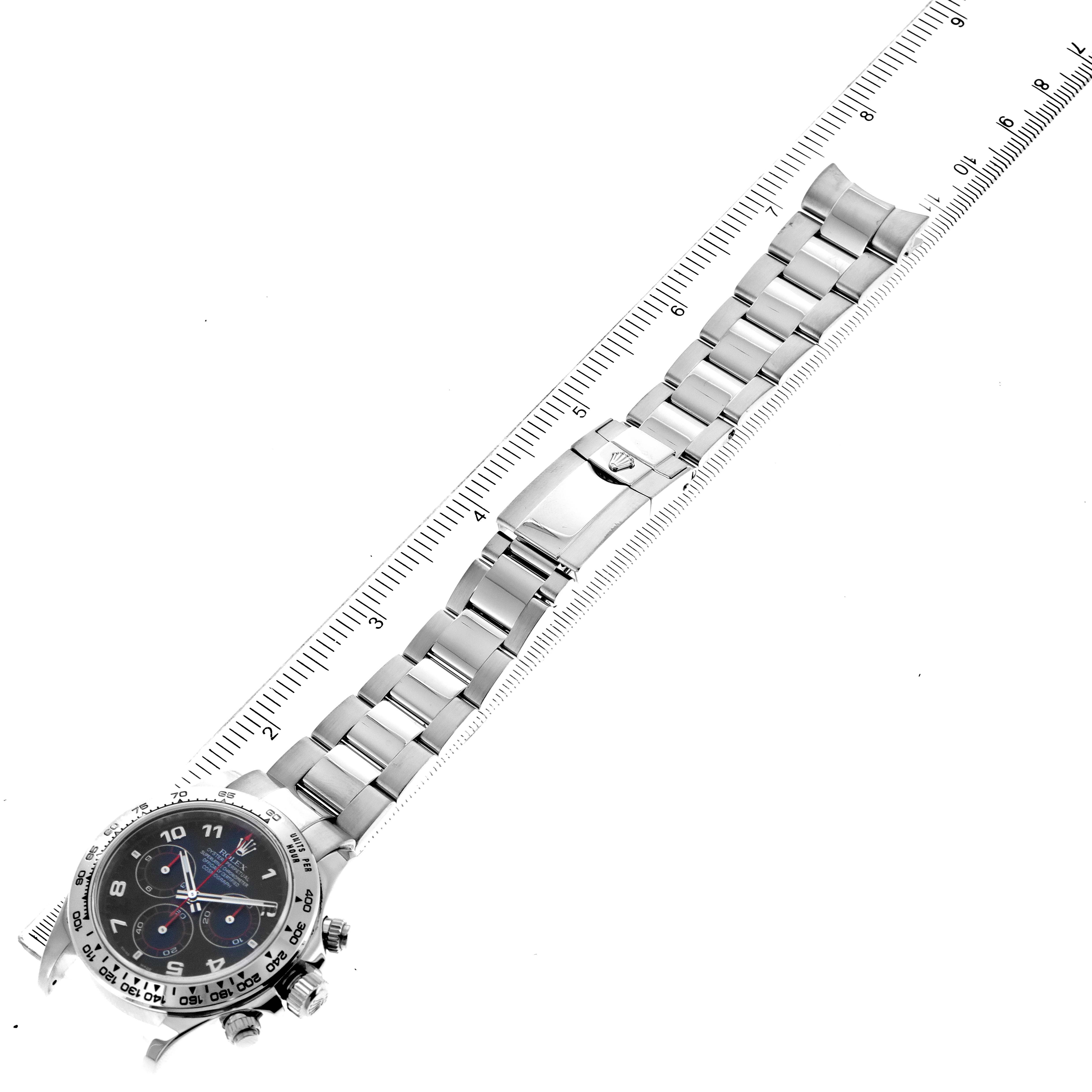 The image shows the Rolex Daytona 116509 Men's White Gold Black Dial 116509 Men's White Gold Black Dial watch laid flat, with the face, bezel, bracelet, and clasp visible next to a ruler.