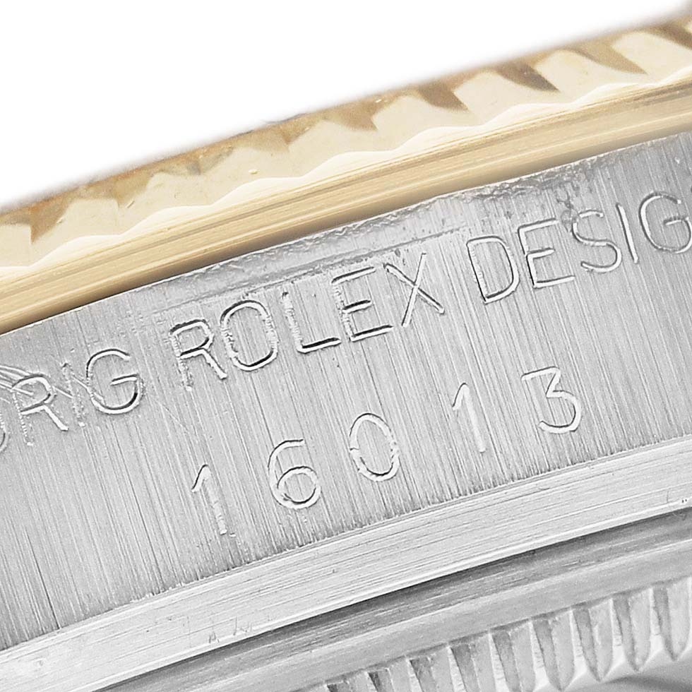 The image shows a close-up of the engraved rim and fluted bezel of a Rolex Datejust 16013 Men's Steel and Gold (two tone) Champagne Dial watch.
