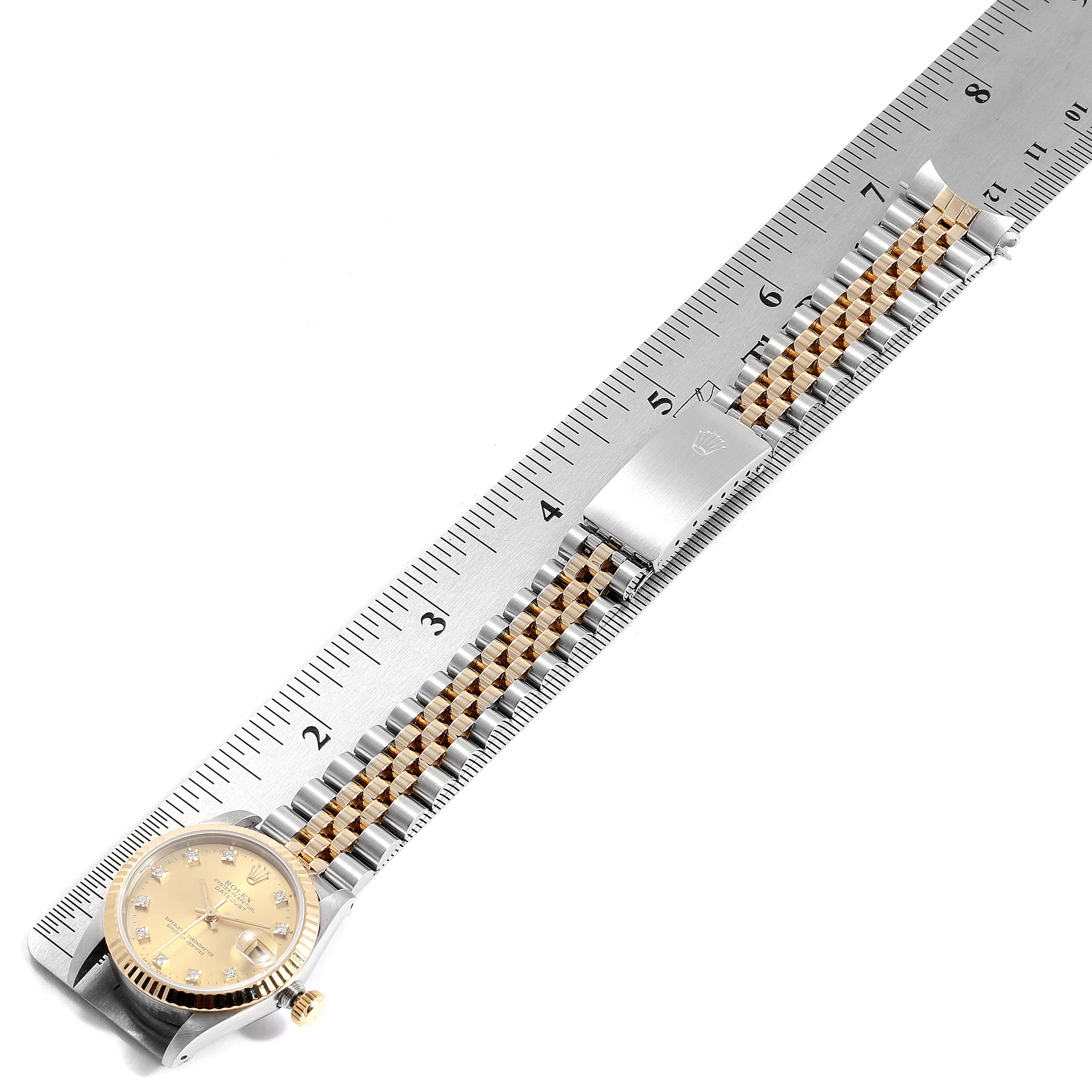 The image shows a side view of a Mid-Size Rolex watch with the face, bezel, bracelet, and a clasp on a ruler for scale.