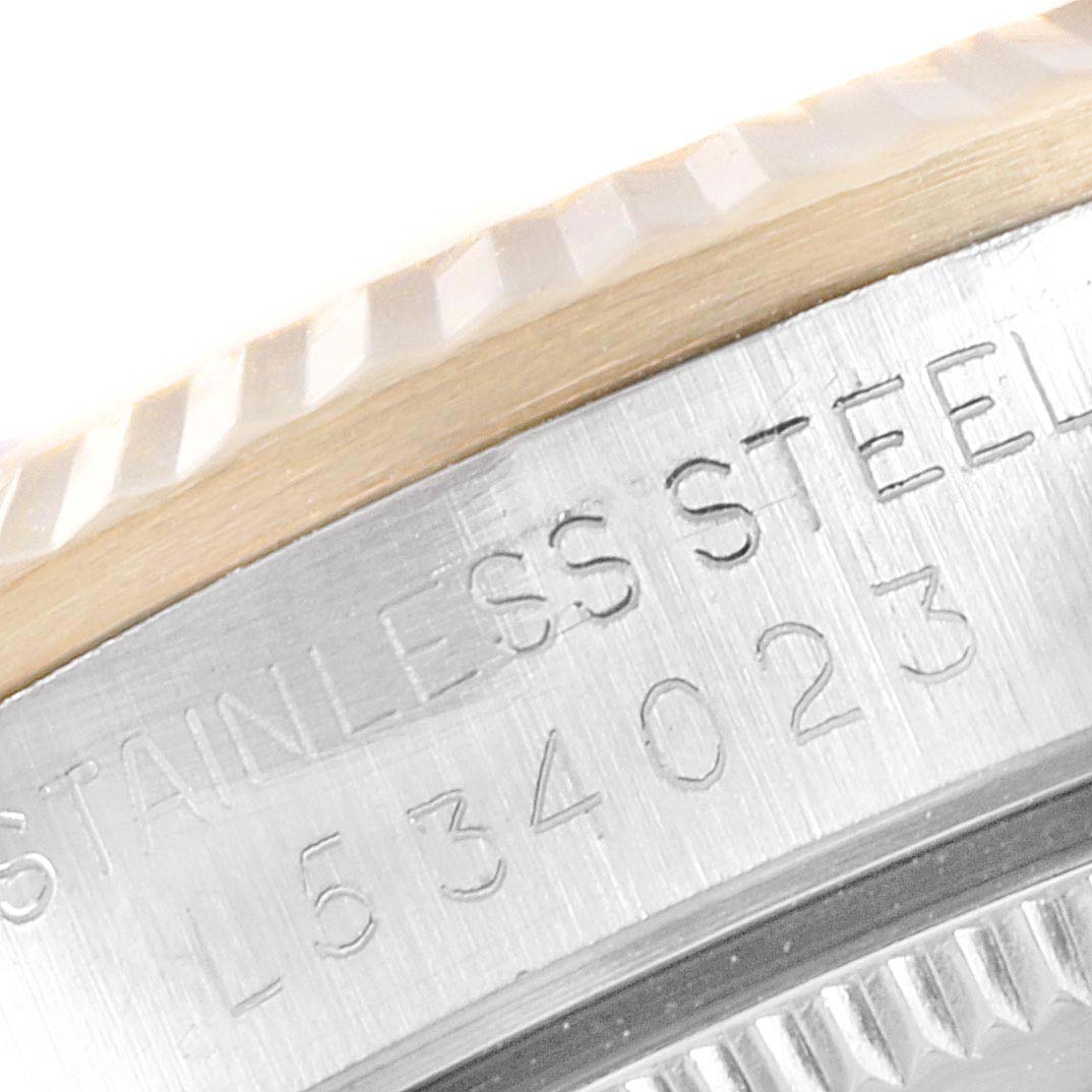 This close-up image shows the bezel and engraved serial number of a Mid-Size Rolex watch.