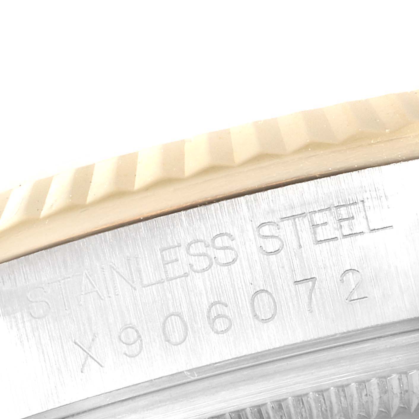 The image shows a close-up of the Rolex Datejust 16233 Men
s Steel and Gold (two tone) Black Dial 16233 Men
s Steel and Gold (two tone) Black Dial model
s stainless steel case back and partially the fluted bezel.