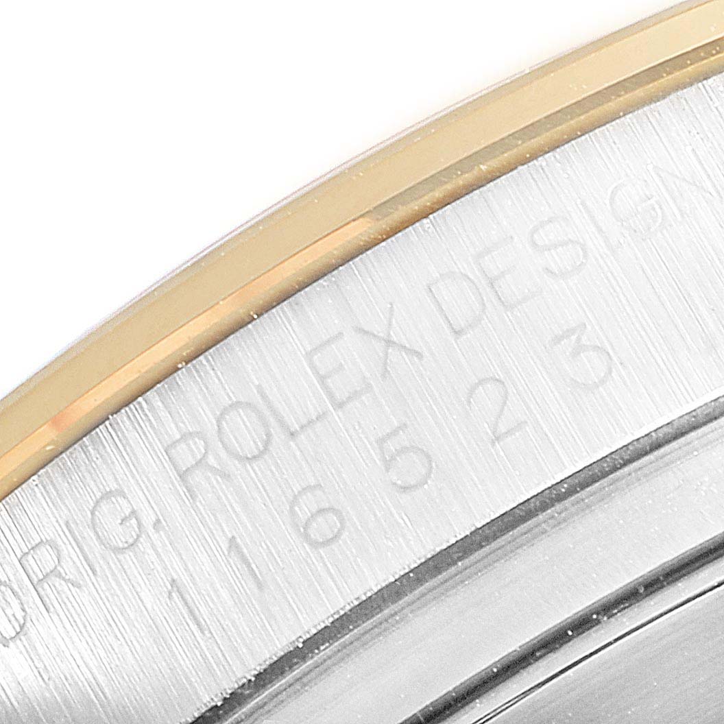 The image captures the model number and part of the bezel on a Rolex Daytona 116523 Men
s Steel and Gold (two tone) Champagne Dial 116523 Men
s Steel and Gold (two tone) Champagne Dial watch.