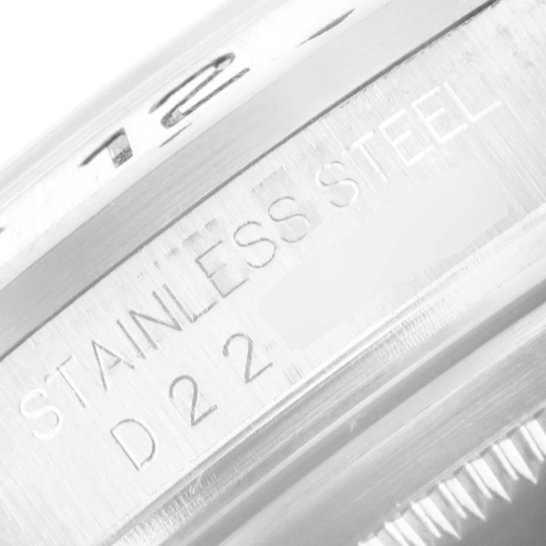 The image shows a close-up of the engraving on the bezel of the Rolex Explorer 16570 Men
s Stainless Steel Black Dial 16570 Men
s Stainless Steel Black Dial watch, indicating "STAINLESS STEEL" and the reference number "D22."