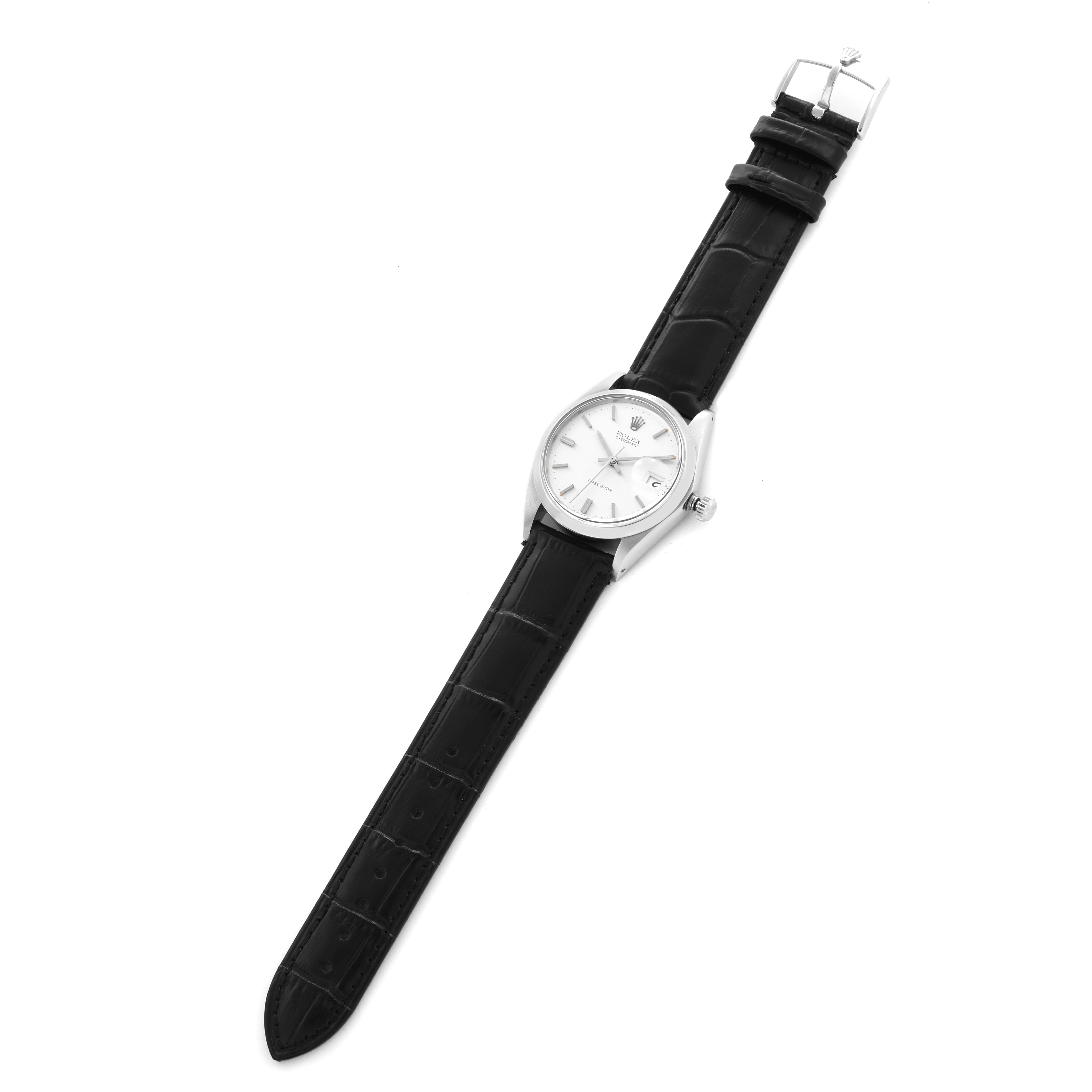 The Rolex Date model watch is shown from a top-down angle, displaying its entire face, case, and black leather strap.