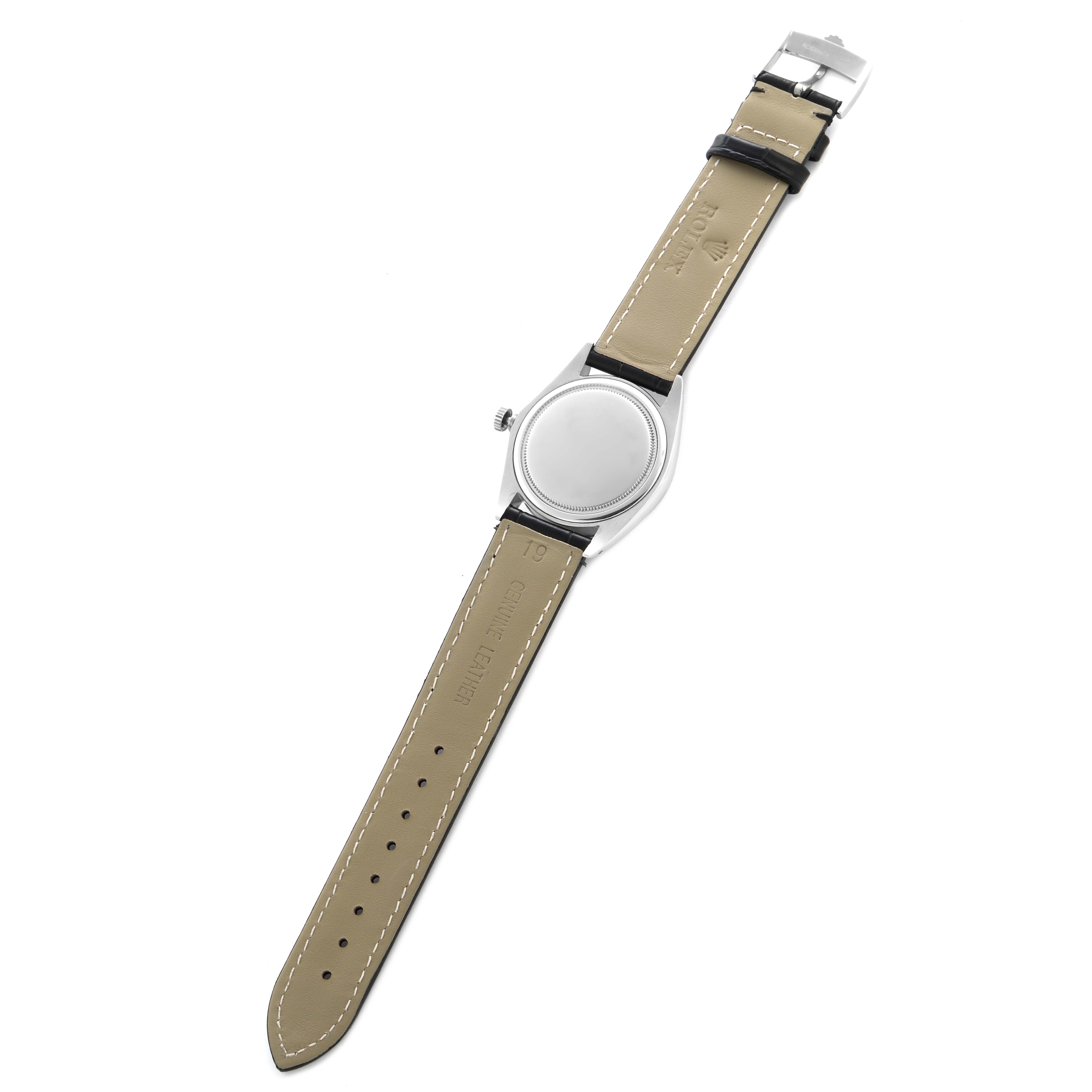 The image shows the back view of a Rolex Date model watch, highlighting the case, crown, and leather strap with a buckle.