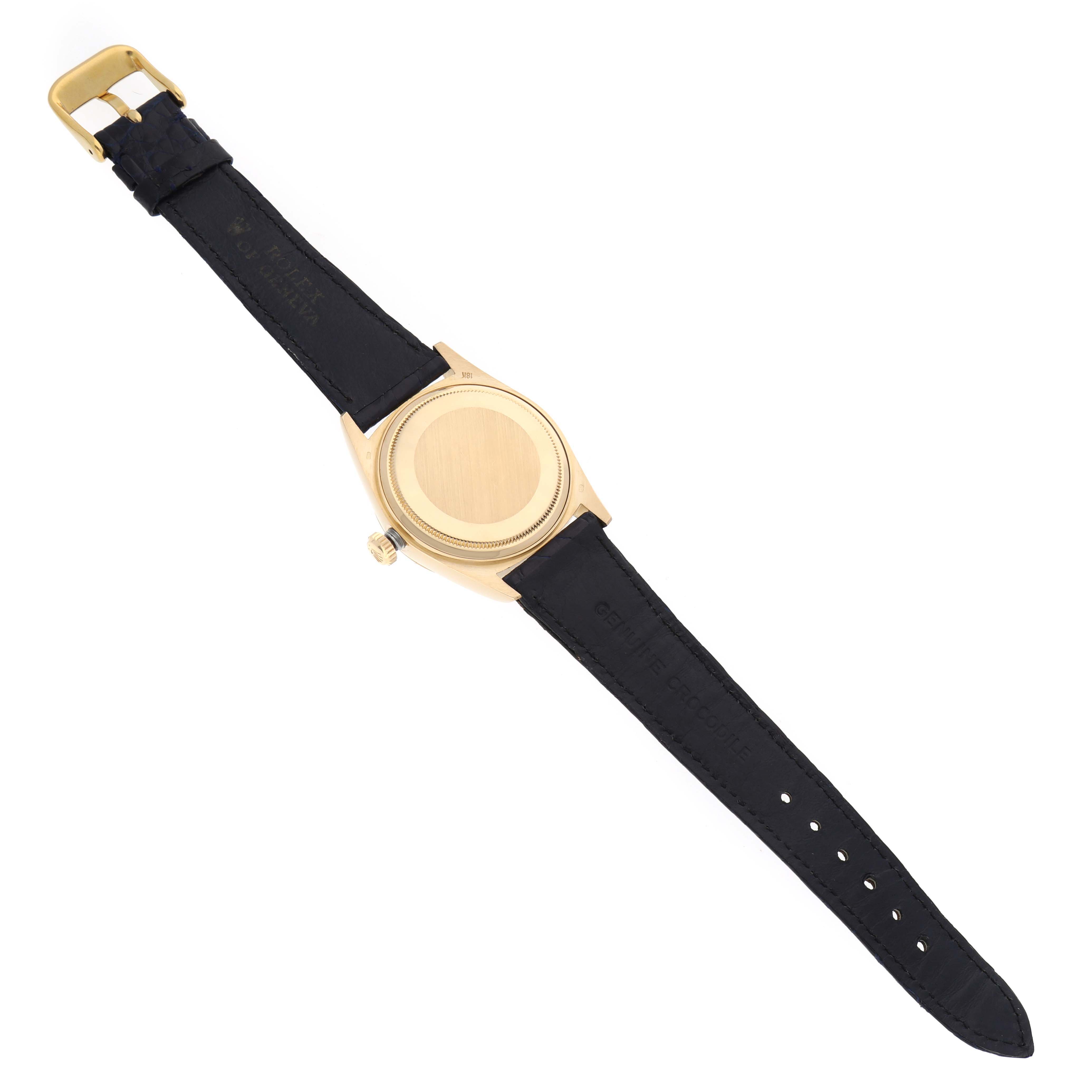 This image shows a President model Rolex watch viewed from the back with a black leather strap.