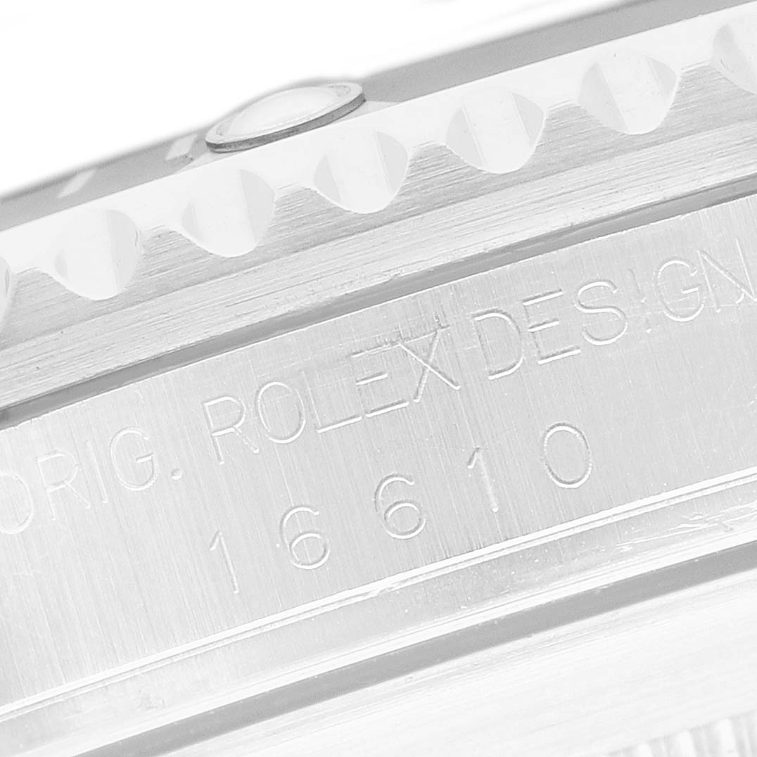 The image shows a close-up of the bezel and engraved side of a Rolex Submariner 16610 Men's Stainless Steel Black Dial model, highlighting the reference number 16610.