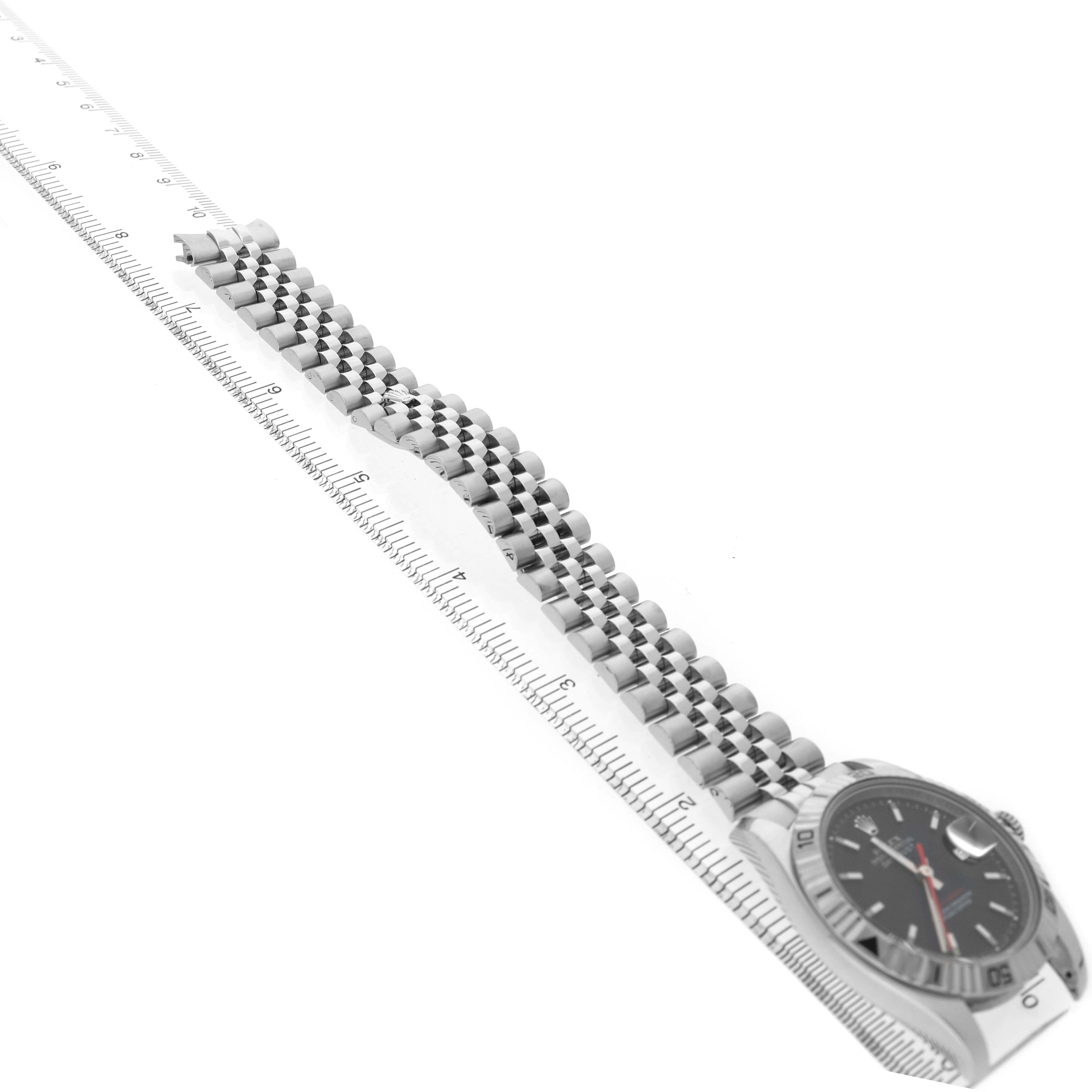 The Rolex Turn-o-Graph 116264 Men's Stainless Steel Black Dial watch is shown at an angle displaying its face and stainless steel bracelet alongside a ruler for scale.