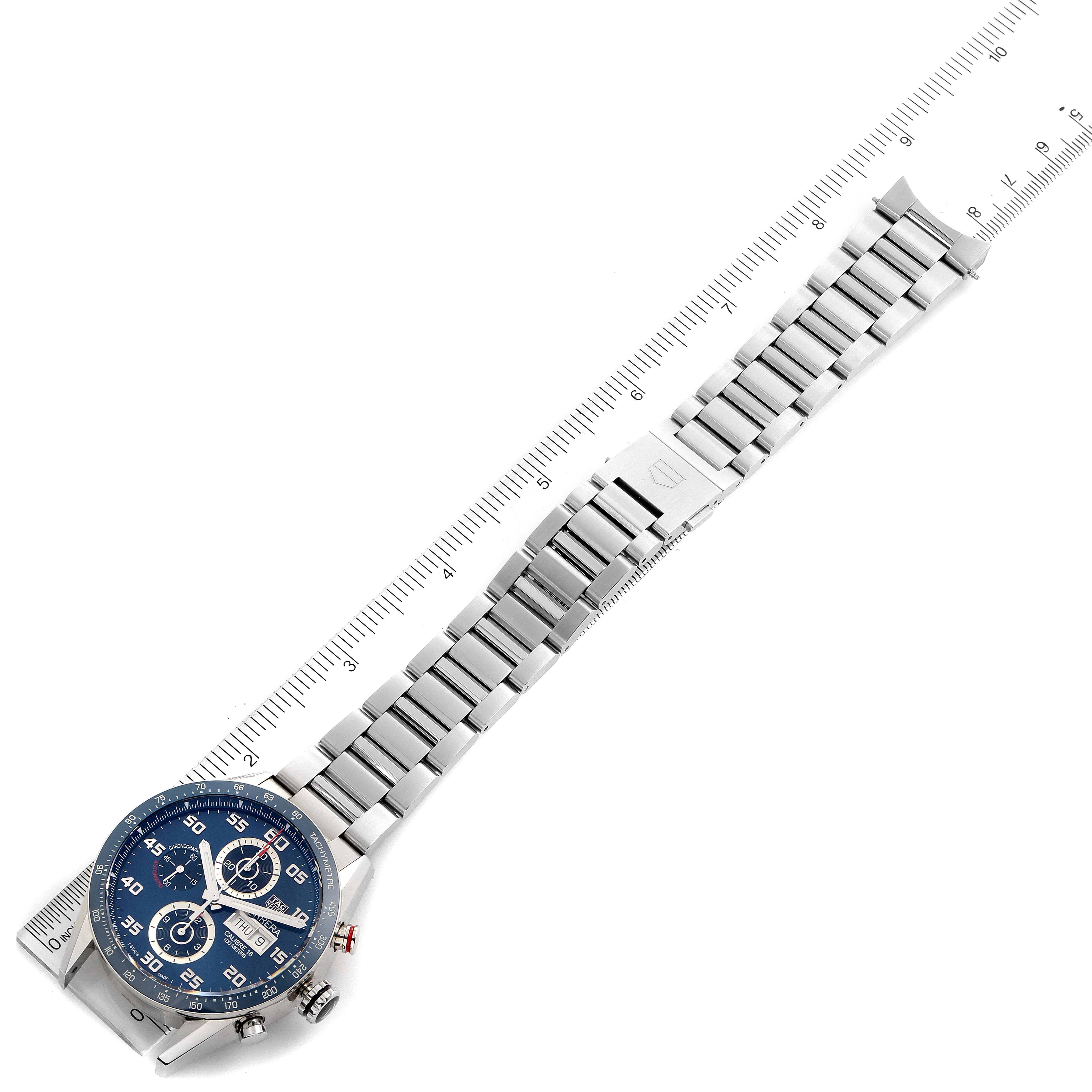 The image shows a top view of a Tag Heuer Carrera CV2A1V.BA0738 Men's Stainless Steel Blue Dial CV2A1V.BA0738 Men's Stainless Steel Blue Dial watch with its metal strap extended alongside a measuring ruler.