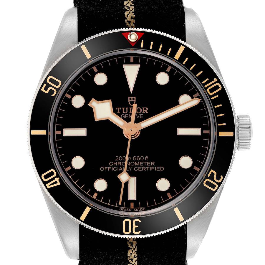 The Tudor Heritage Black Bay watch is shown from a top-down angle, highlighting its dial, bezel, and crown.
