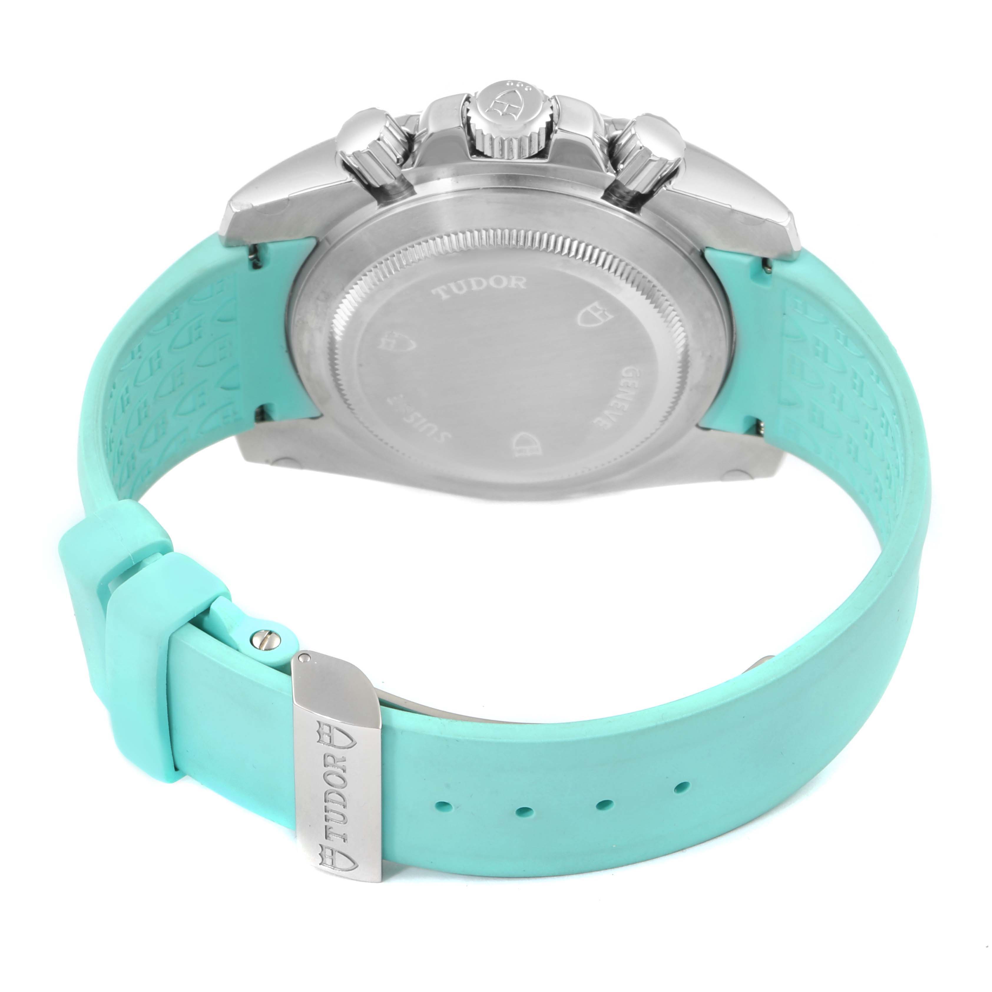 This image shows the back view of a Tudor Grantour 20310 Men
s Stainless Steel White Dial 20310 Men
s Stainless Steel White Dial watch, highlighting its case back, crown, and turquoise strap.