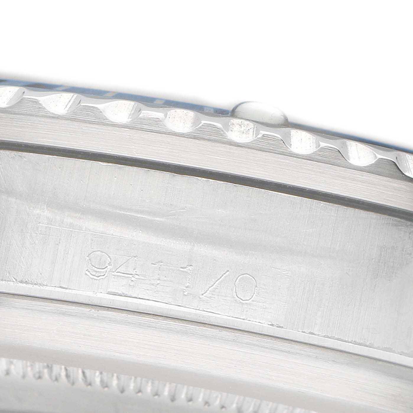 The image shows a close-up of the side of a Tudor Submariner 9411 Men's Stainless Steel Blue Dial watch case, highlighting the bezel and engraved model number.