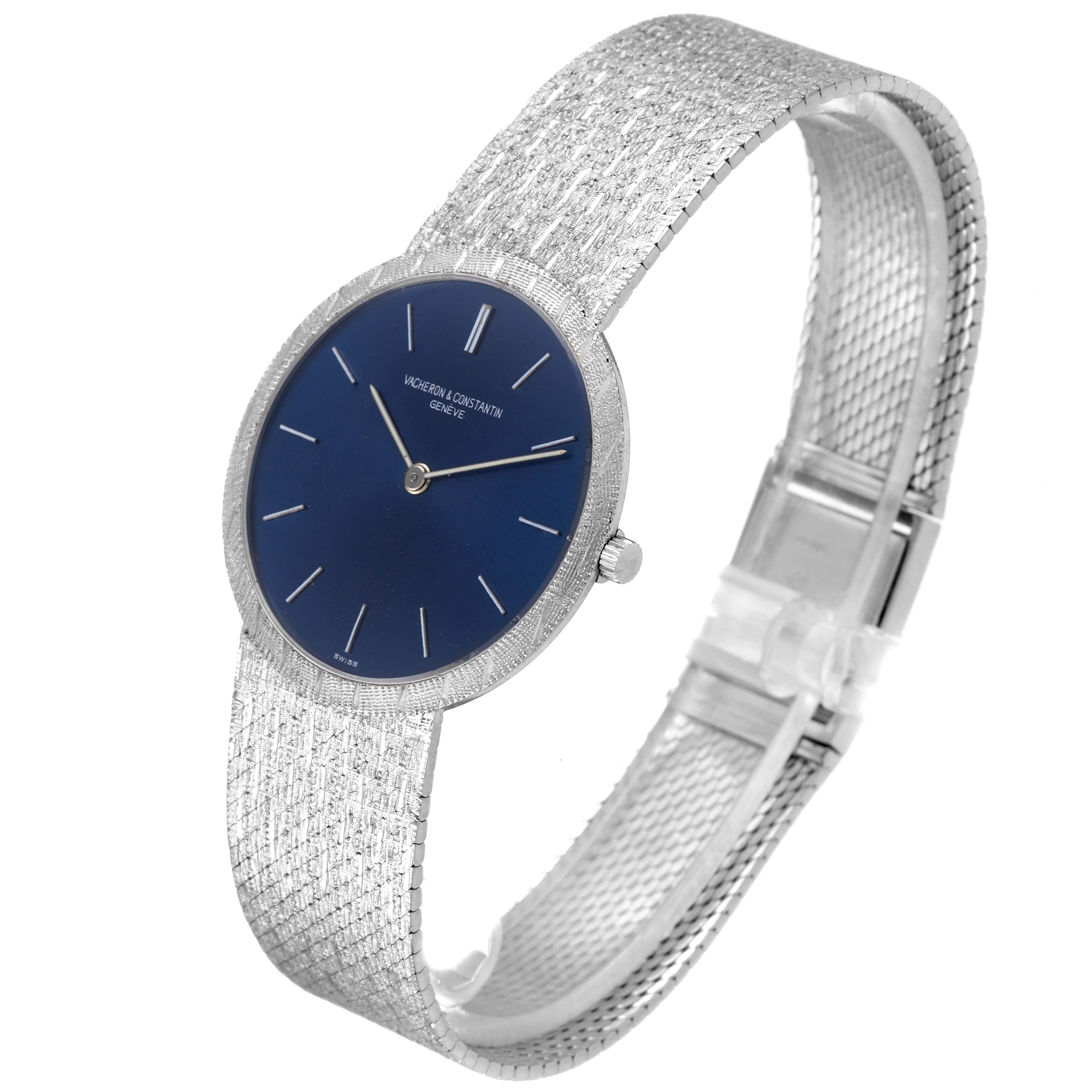 The image shows a Vacheron Constantin Patrimony 6352 Men's White Gold Blue Dial 6352 Men's White Gold Blue Dial watch at an angle highlighting its blue dial, thin hands, textured bezel, and mesh bracelet.