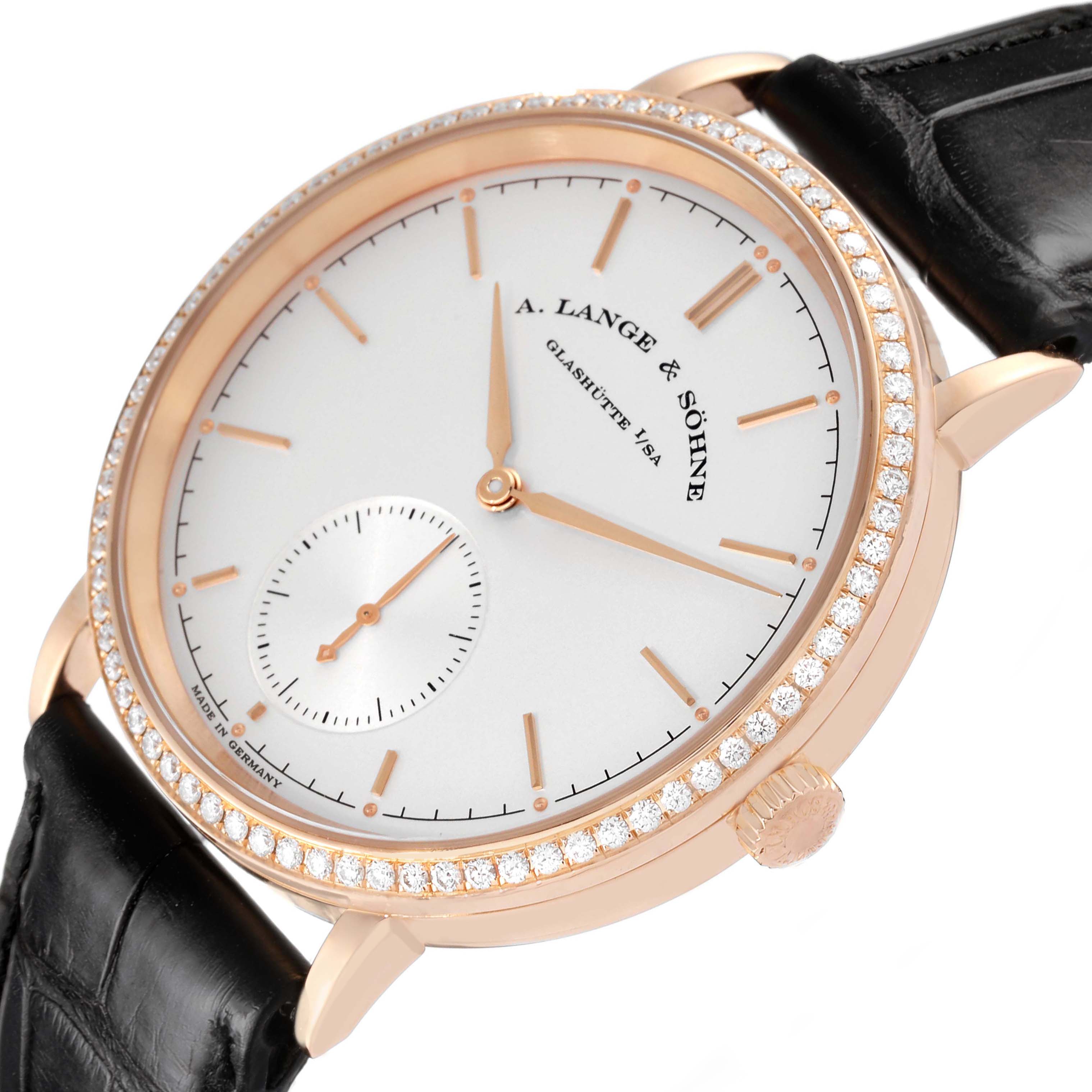 The Saxonia by A. Lange & Söhne is shown at a slight angle, highlighting the face, diamond bezel, crown, and black leather strap.