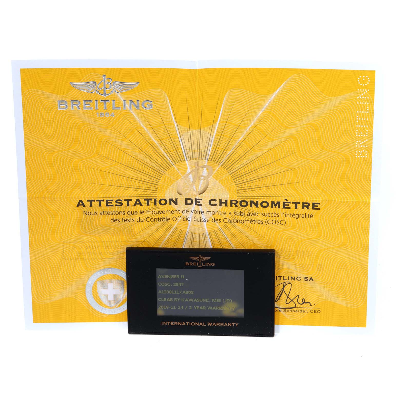 The image shows a Breitling Avenger A13381 Men's Stainless Steel Mother of Pearl Dial A13381 Men's Stainless Steel Mother of Pearl Dial's COSC certificate and international warranty card placed on top of it.