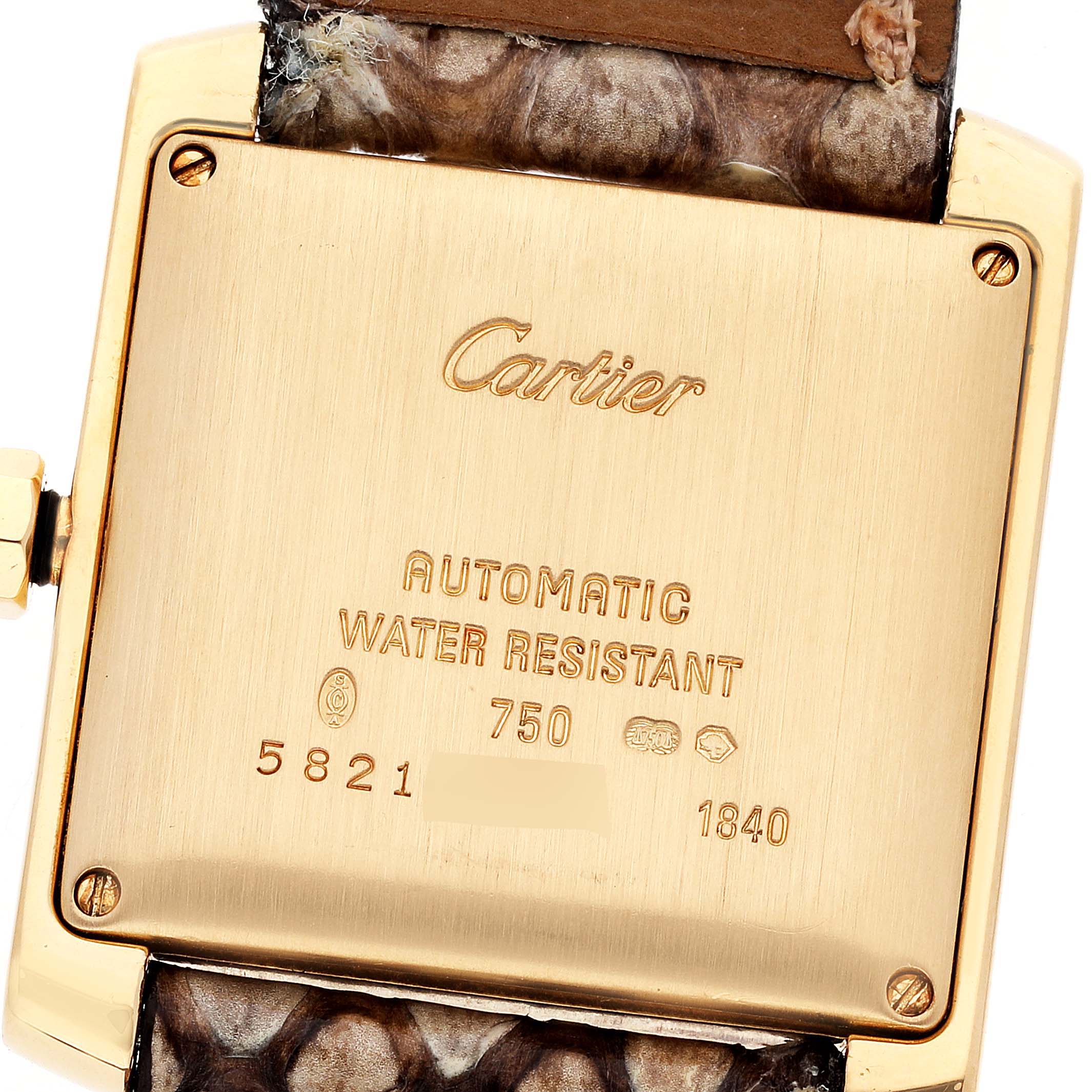 This image shows the back case of a Cartier Tank Française watch with engraved details and part of the strap.