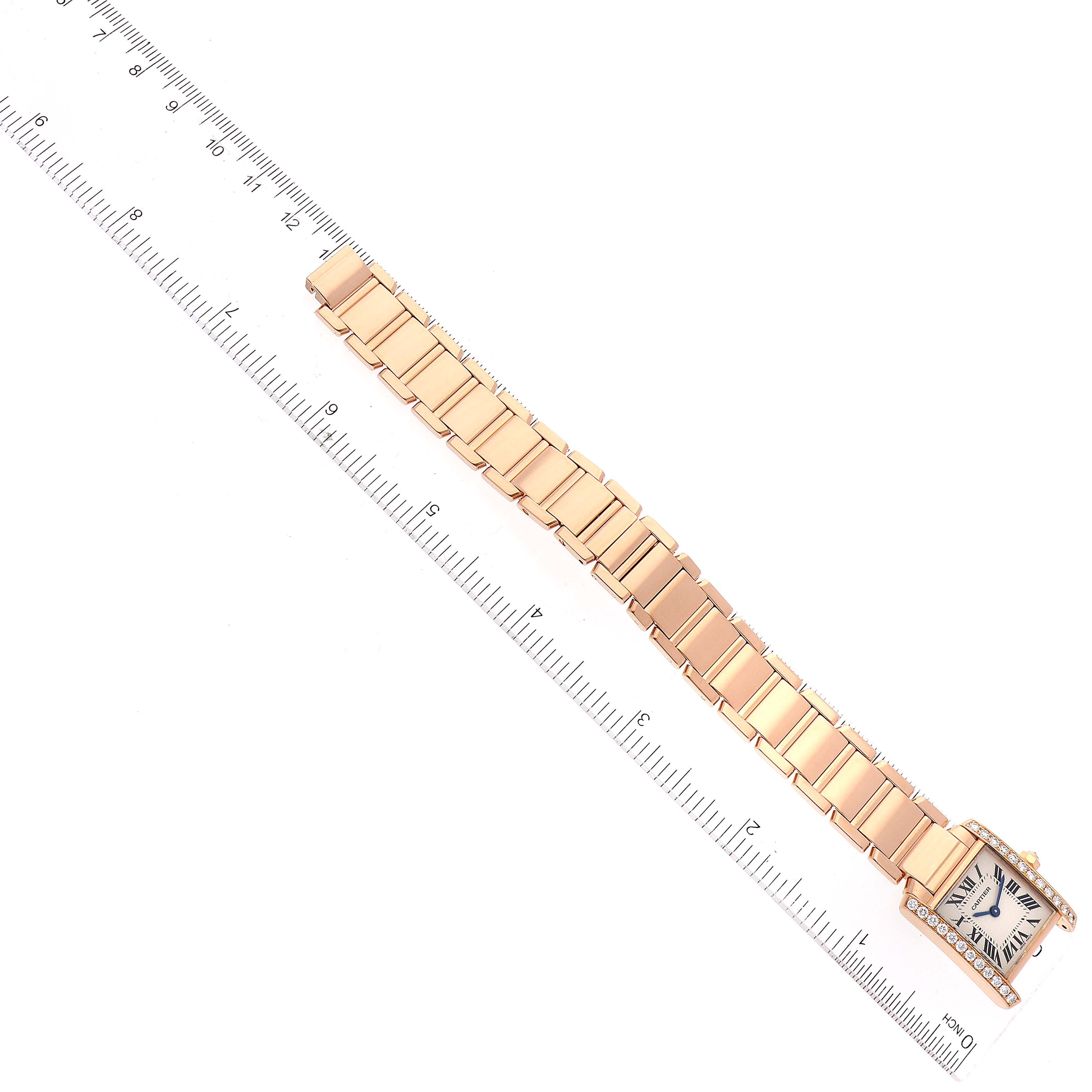 The image shows the Cartier Tank Francaise WJTA0022 Women's Rose Gold Silver Dial WJTA0022 Women's Rose Gold Silver Dial watch from a top-down angle, displaying the full length of its bracelet and face next to a ruler.