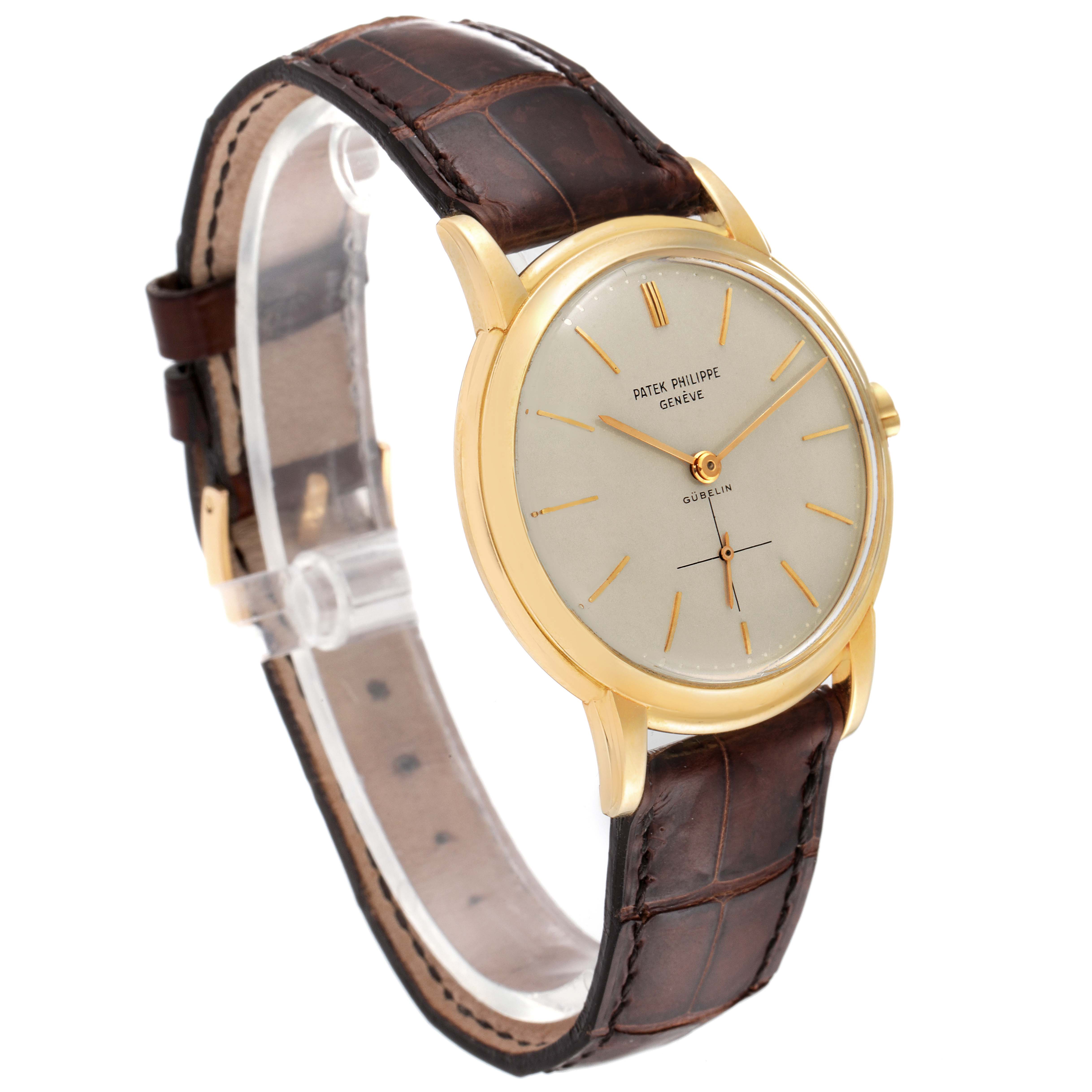 The Patek Philippe Calatrava 2551J Men's Yellow Gold Silver Dial 2551J Men's Yellow Gold Silver Dial watch is shown at a slight angle, displaying its gold casing, brown leather strap, and dial details.