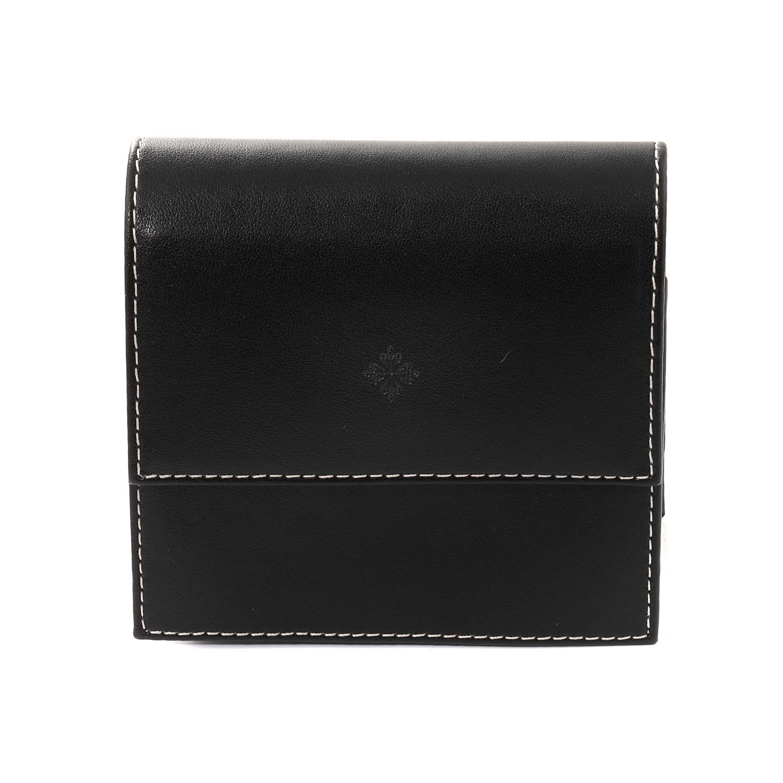 The image shows a black leather watch case, likely for a Nautilus model by Patek Philippe, with white stitching.