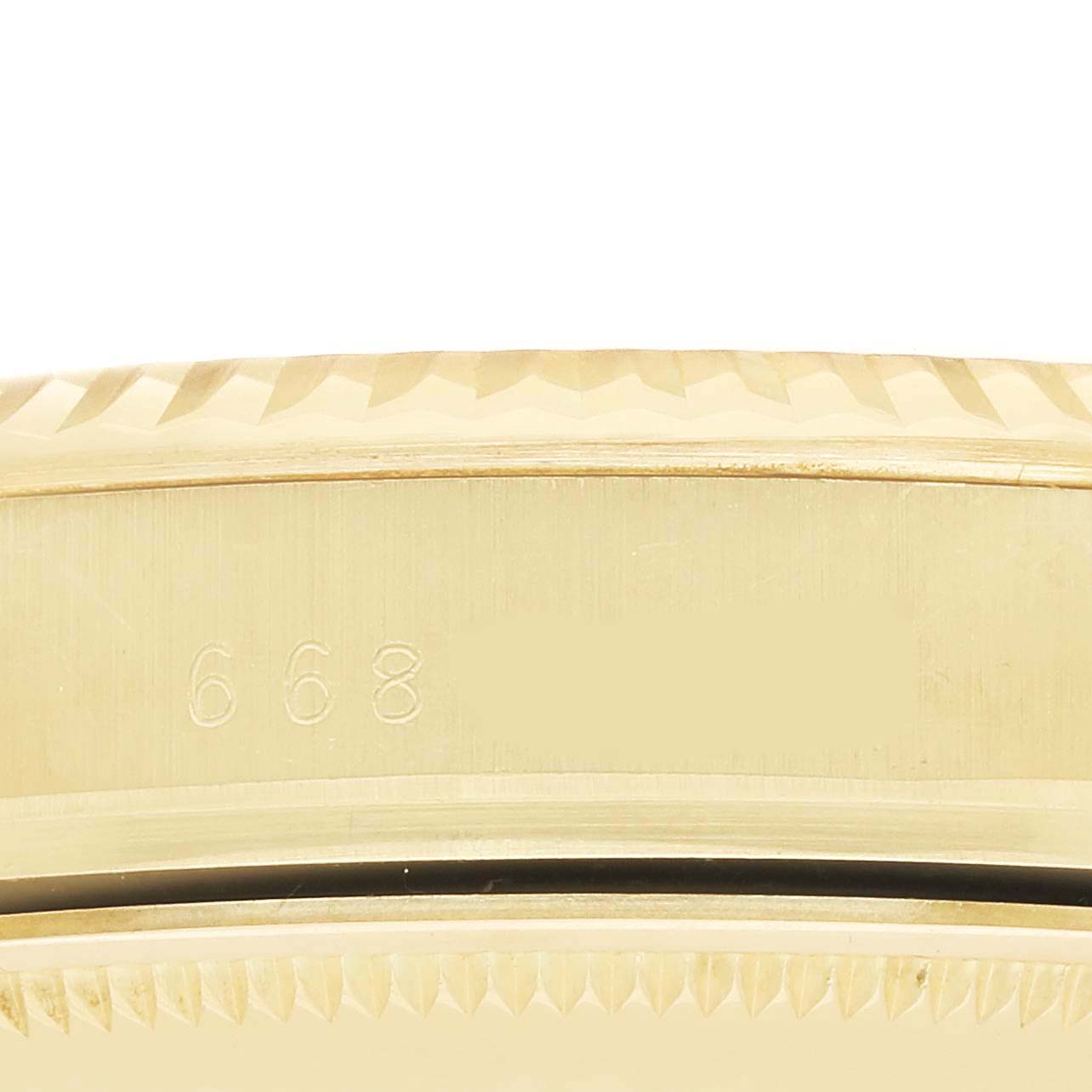 The image shows the side view of a Rolex Date 15037 Men
s Yellow Gold Champagne Dial 15037 Men
s Yellow Gold Champagne Dial watch, focusing on the engraved edge of the bezel.