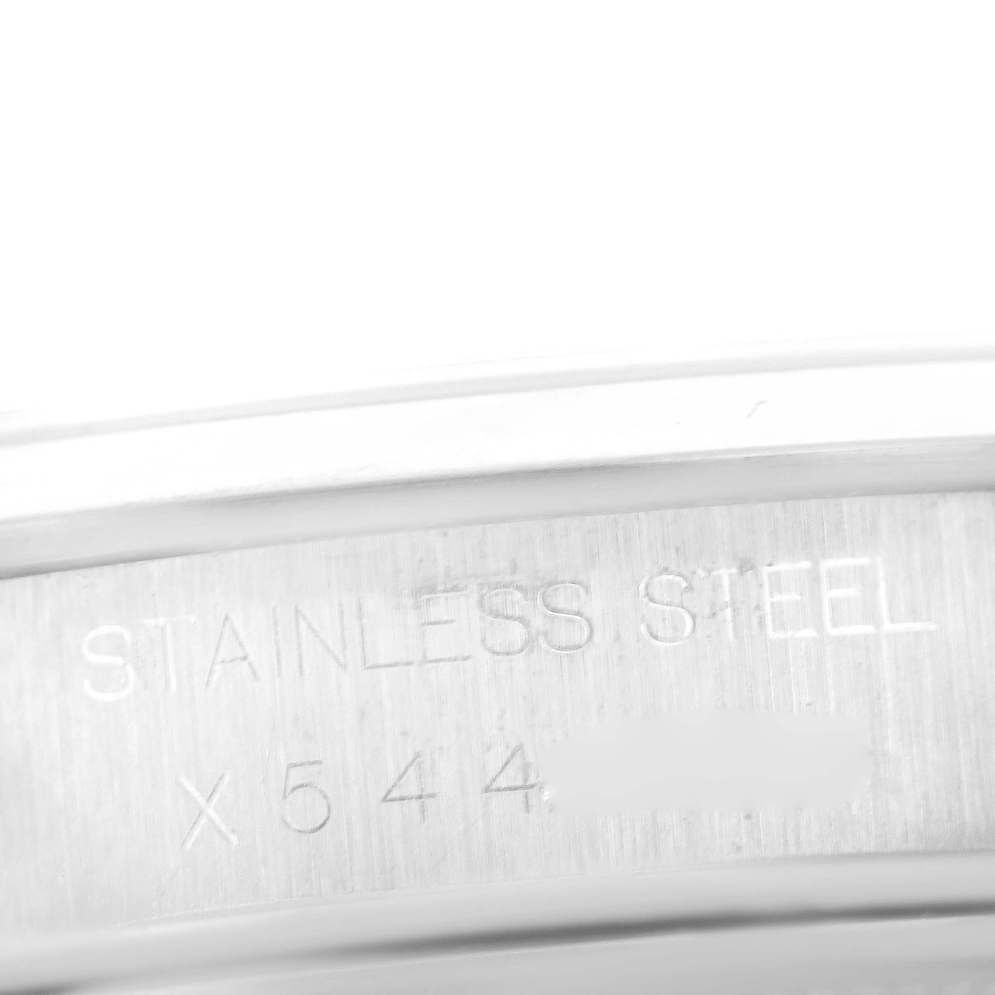 The image shows a close-up of the underside of the case of a Rolex Date 15200 Men's Stainless Steel Silver Dial 15200 Men's Stainless Steel Silver Dial model, displaying "STAINLESS STEEL" and part of the serial number.