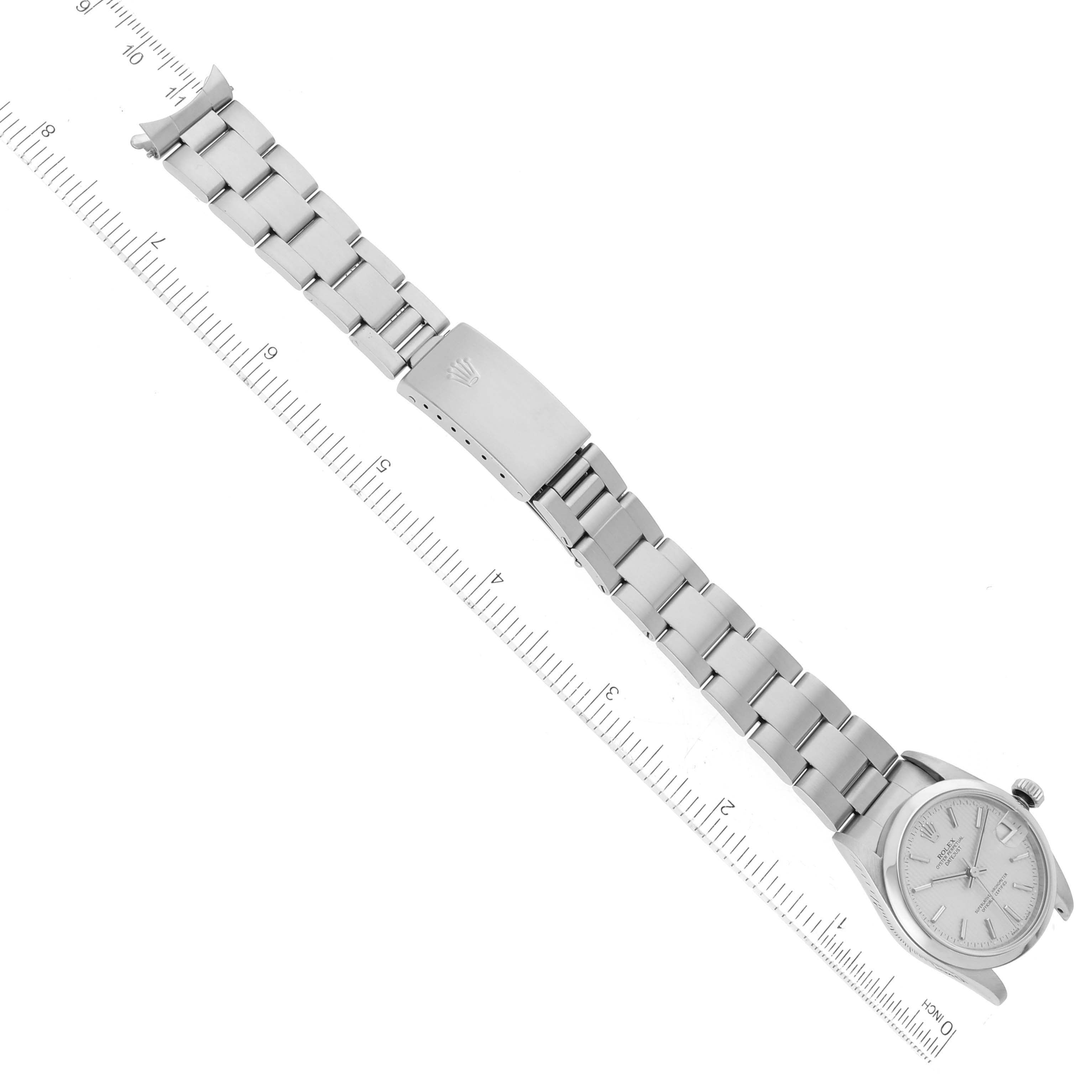 The Rolex Mid-Size 78240 Women's Stainless Steel Silver Dial 78240 Women's Stainless Steel Silver Dial watch is shown from an overhead angle, displaying the dial, bracelet, and clasp with a ruler for scale.