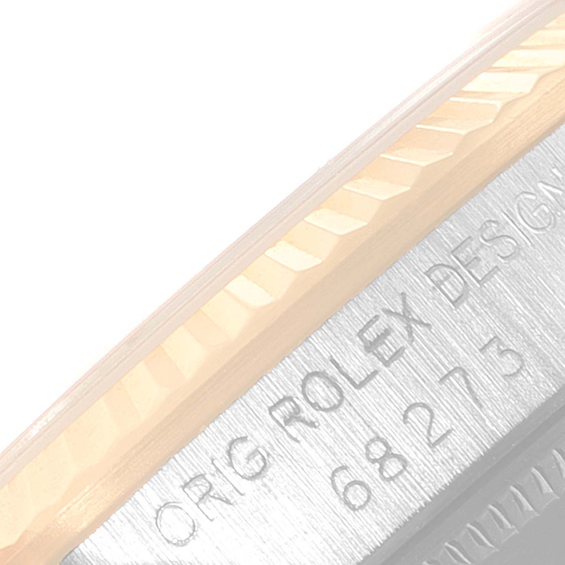 This image shows a close-up of the case side and bezel edge of a Rolex Mid-Size 68273 Women
s Steel and Gold (two tone) Champagne Dial 68273 Women
s Steel and Gold (two tone) Champagne Dial watch, featuring engraved text.