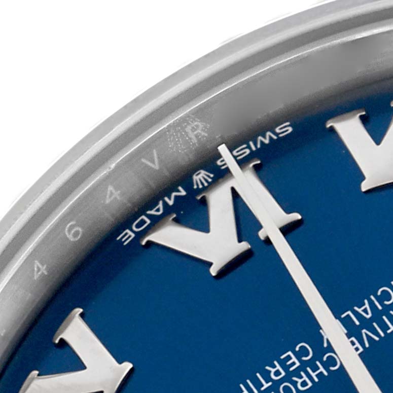 The image shows a close-up of the Rolex Mid-Size 278274 Women
s Stainless Steel Blue Dial 278274 Women
s Stainless Steel Blue Dial watch
s bezel, dial, and Roman numerals from an angled top view.