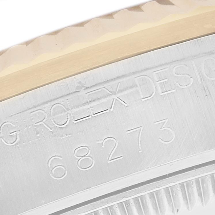 The image shows a close-up of the engraved side of a Rolex Mid-Size 68273 Women's Steel and Gold (two tone) White Dial 68273 Women's Steel and Gold (two tone) White Dial 68273 watch, focusing on the case details and edge.