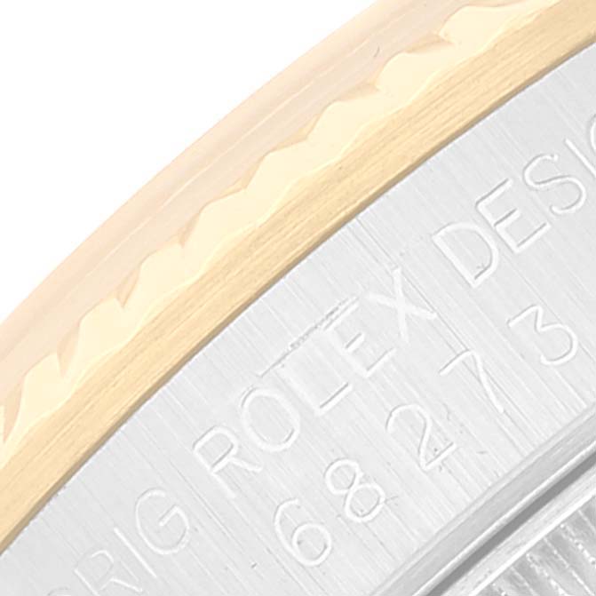This close-up shows the edge of the bezel and engraving on the case of a Mid-Size Rolex watch.