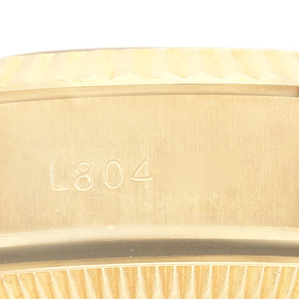 This image shows a close-up of the case side and bezel of a Rolex President 69178 Women's Yellow Gold White Dial 69178 Women's Yellow Gold White Dial model watch, featuring part of the serial number.