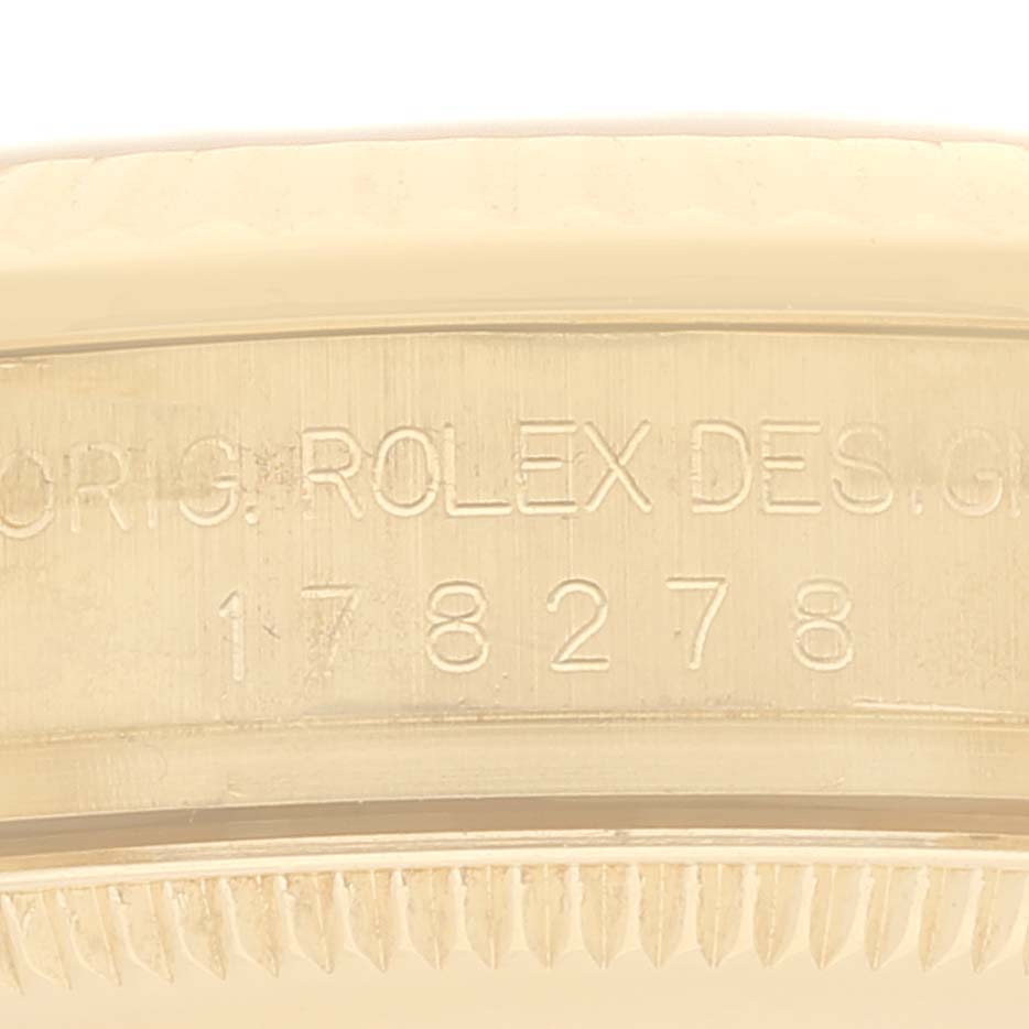 This close-up image shows the engravings on the side of the bezel of a Rolex President 178278 Women's Yellow Gold Black Dial 178278 Women's Yellow Gold Black Dial model.