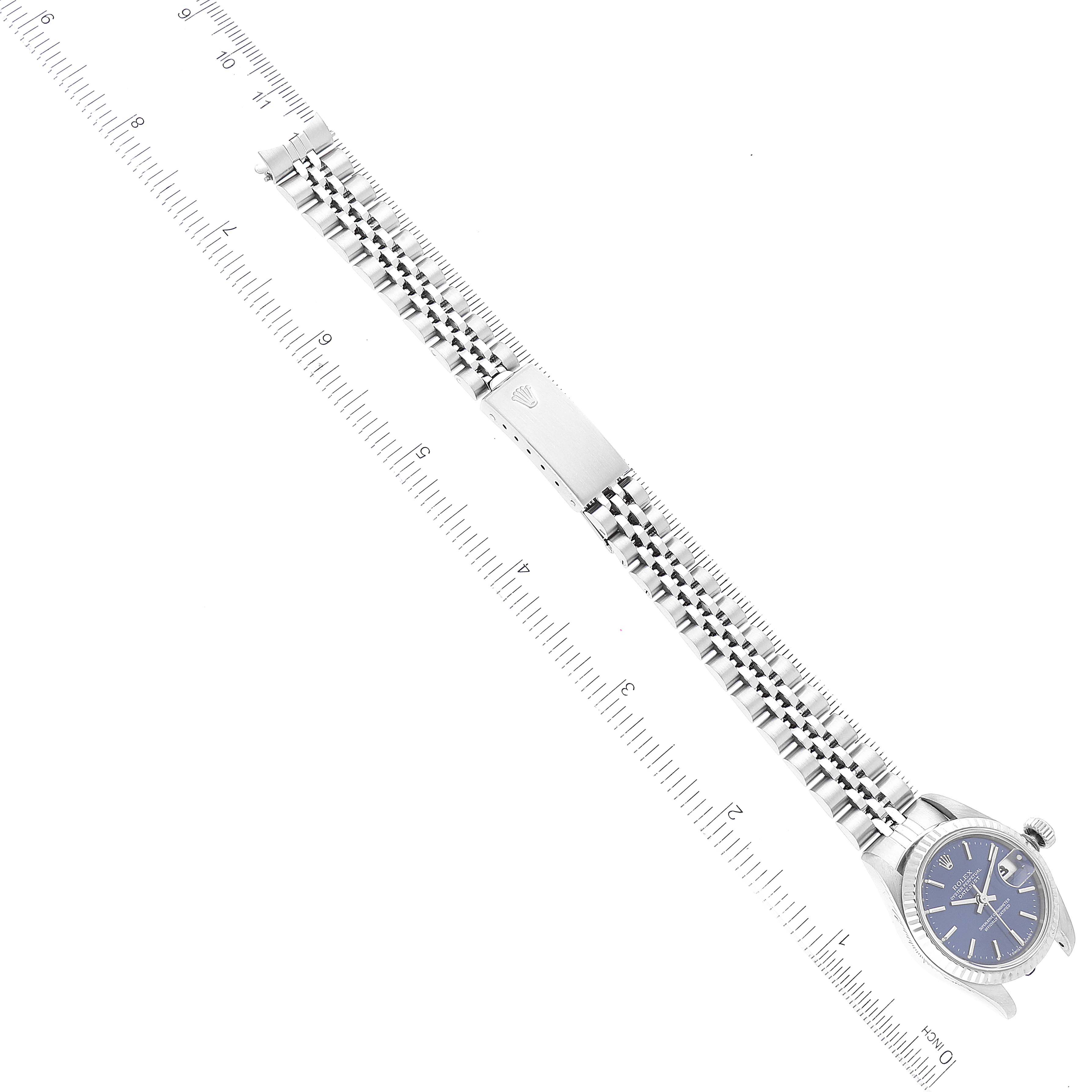 The Rolex Datejust 69174 Women's Stainless Steel Blue Dial 69174 Women's Stainless Steel Blue Dial watch is shown at an angle, displaying the face, bracelet, and clasp with a ruler alongside for scale.