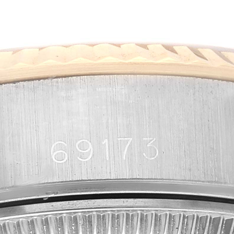 The image shows a close-up of the side of a Rolex Datejust 69173 Women's Steel and Gold (two tone) White Dial 69173 Women's Steel and Gold (two tone) White Dial watch, focusing on the serial number and bezel.
