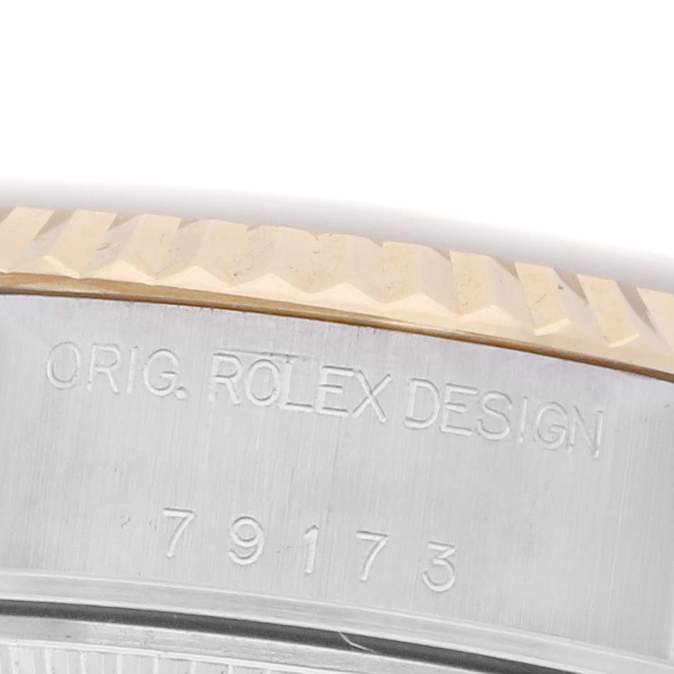 The image shows a close-up of the Rolex Datejust 79173 Women's Steel and Gold (two tone) White Dial 79173 Women's Steel and Gold (two tone) White Dial bezel and case edge with engraved model details.