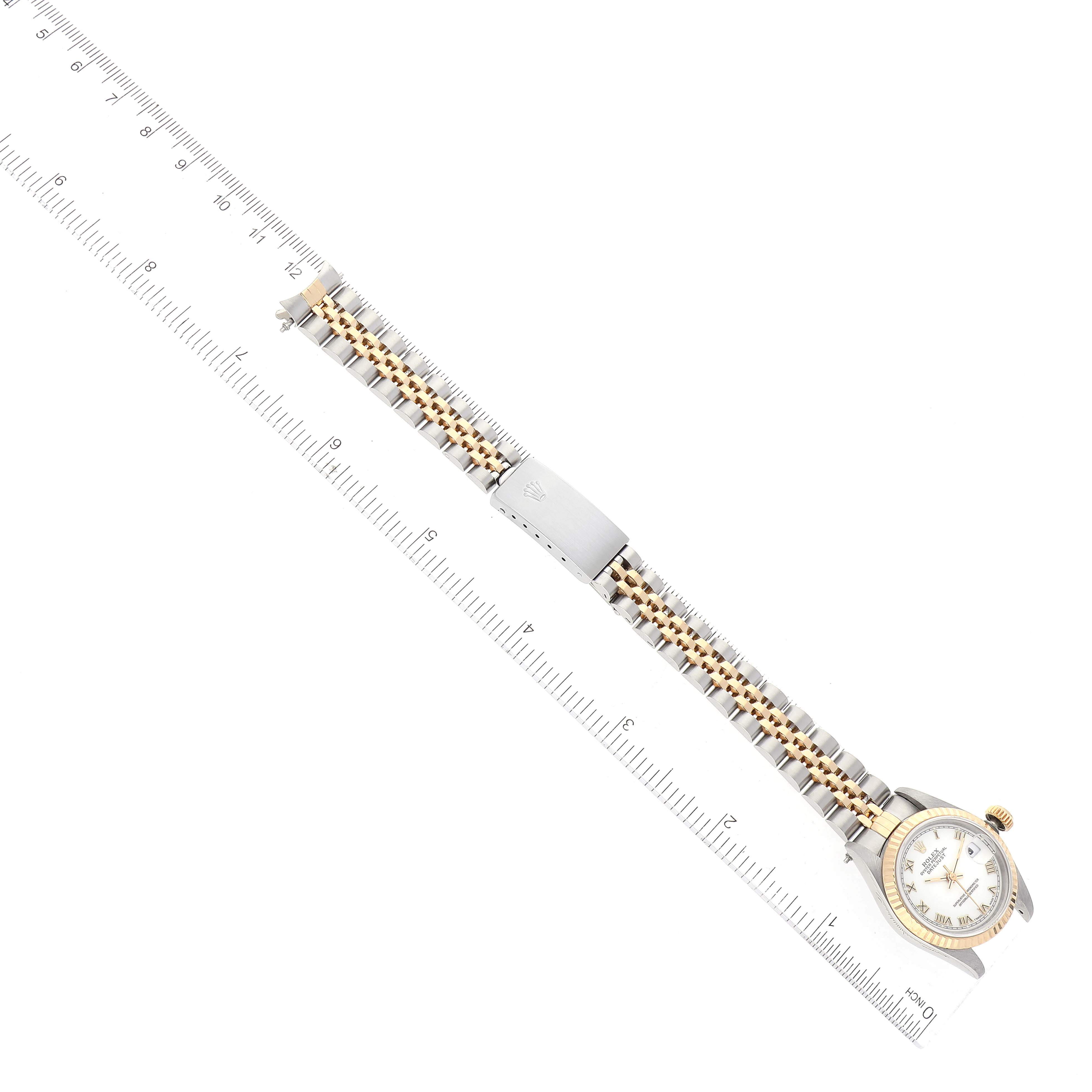 The image shows a Rolex Datejust 69173 Women's Steel and Gold (two tone) White Dial 69173 Women's Steel and Gold (two tone) White Dial watch at a top-down angle, displaying its face, bracelet, and clasp alongside a ruler.