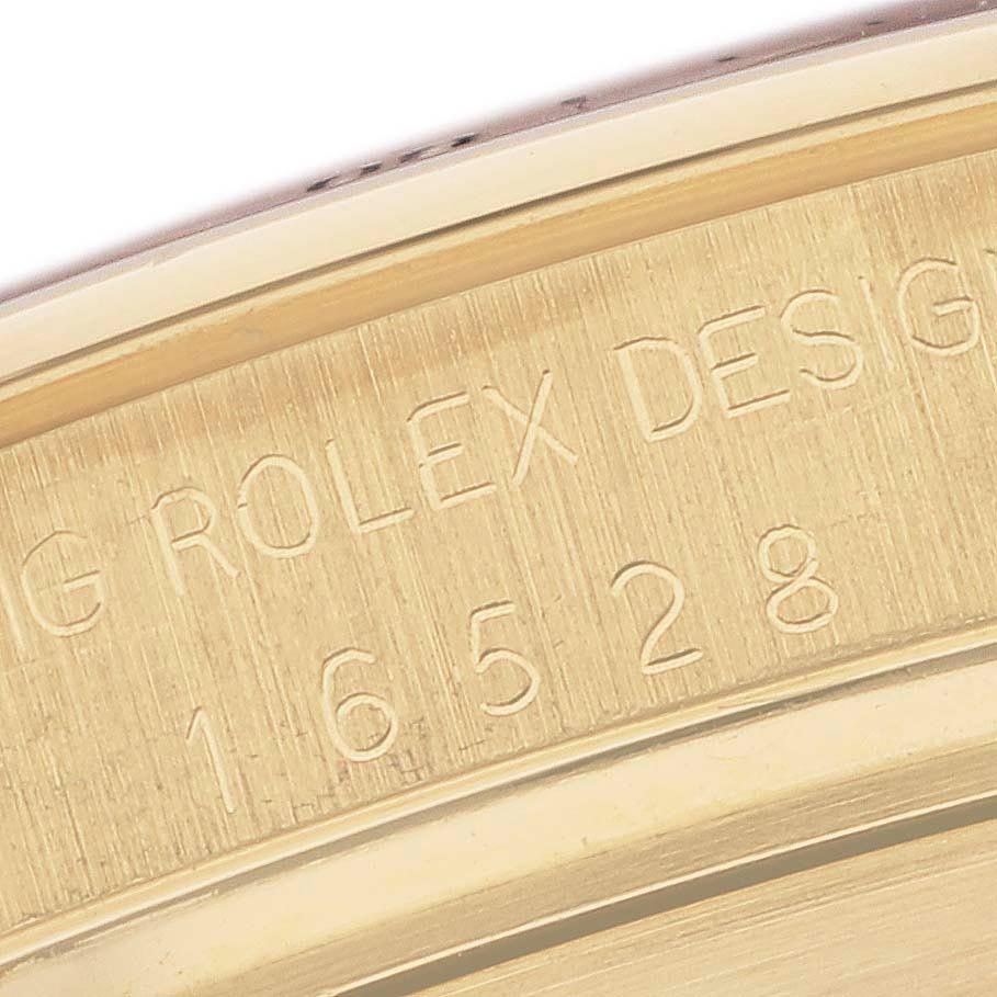 The image shows a close-up of the engraved inner bezel of a Rolex Daytona 16528 Men's Yellow Gold White Dial 16528 Men's Yellow Gold White Dial, displaying text and numbers.