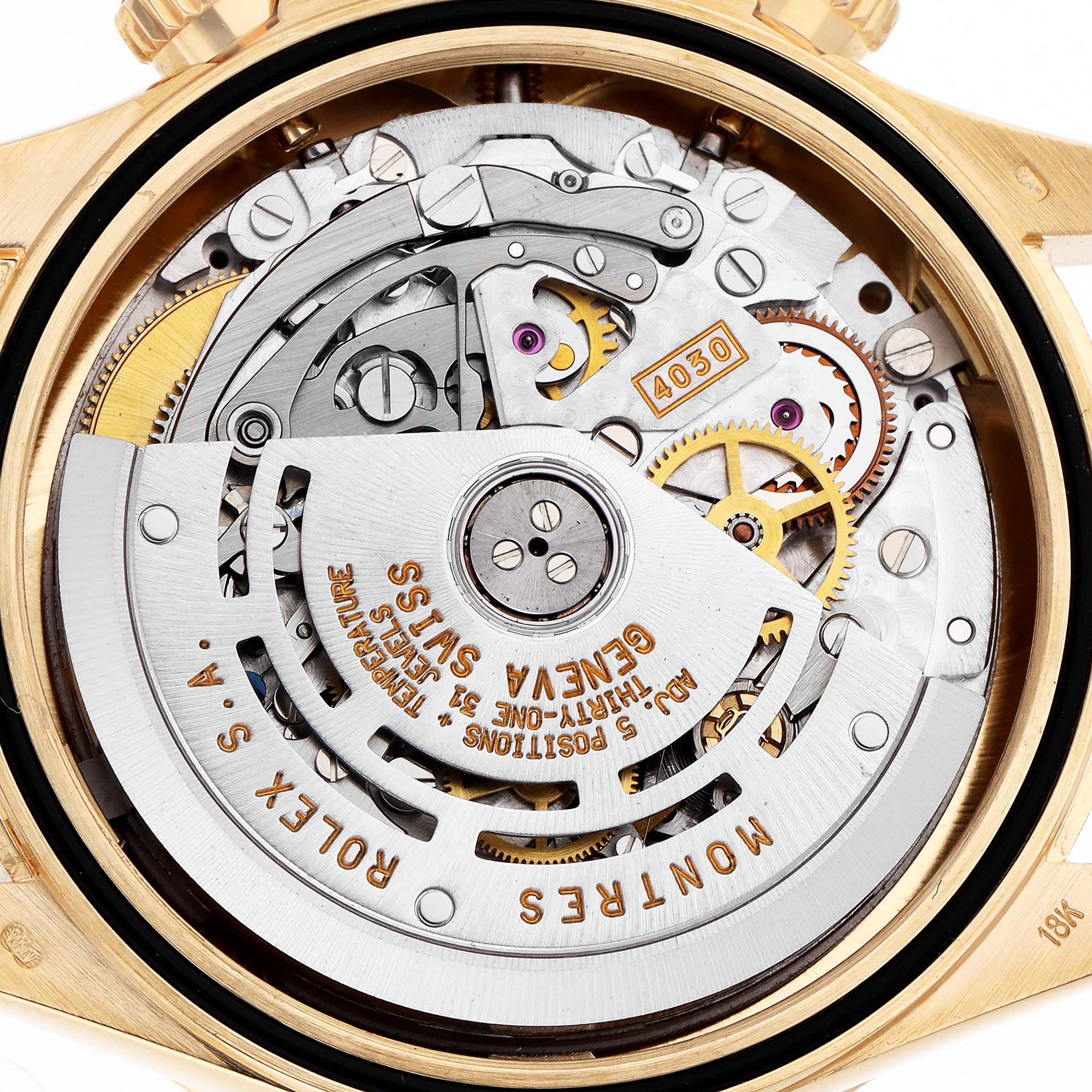 The image shows a close-up of the Rolex Daytona 16528 Men's Yellow Gold White Dial 16528 Men's Yellow Gold White Dial's movement from the back, highlighting its intricate gears and inscriptions.